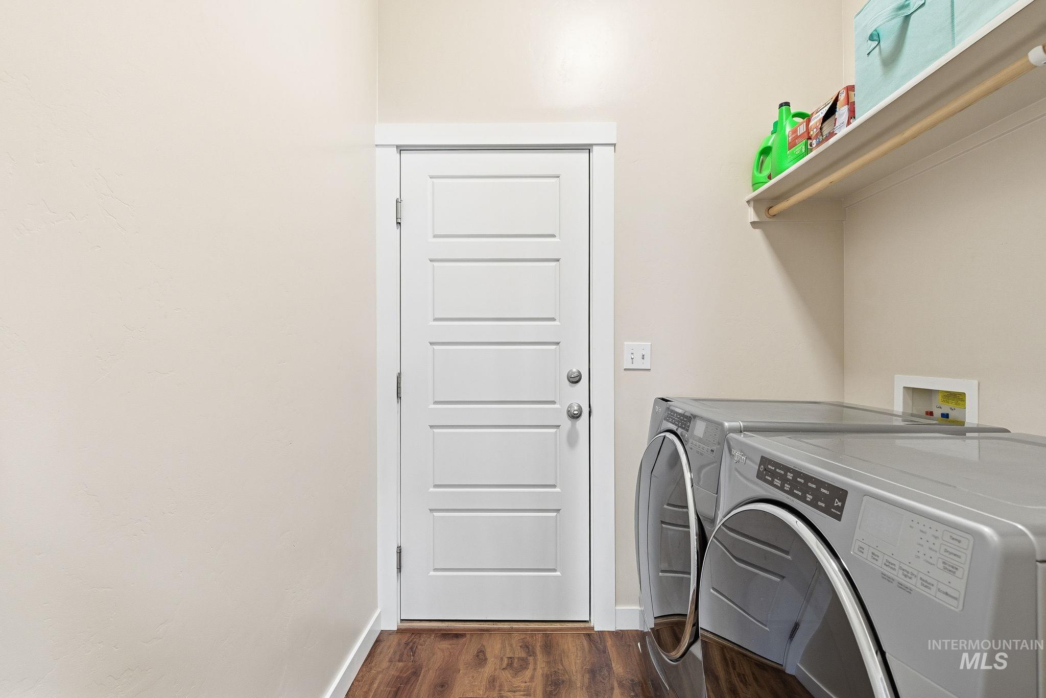 Washroom with dark wood-type flooring and independent washer and dryer
