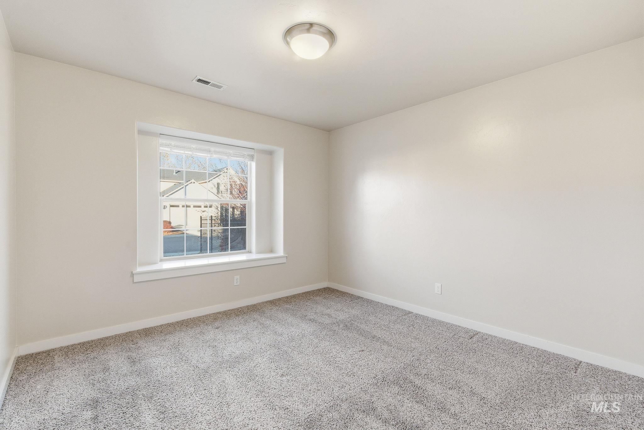 Carpeted empty room featuring baseboards