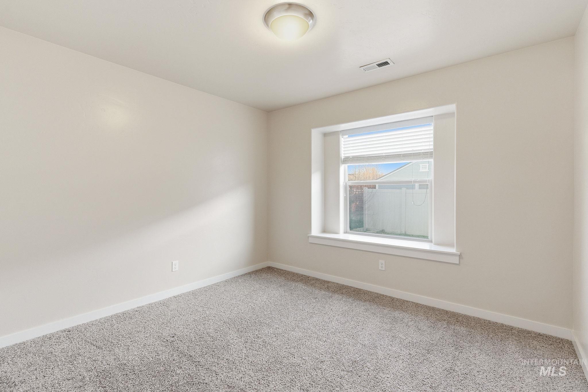 Carpeted empty room with baseboards