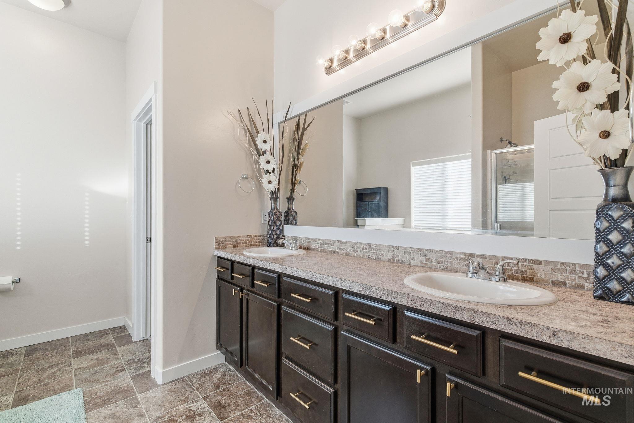 Bathroom with double vanity and a shower with shower door