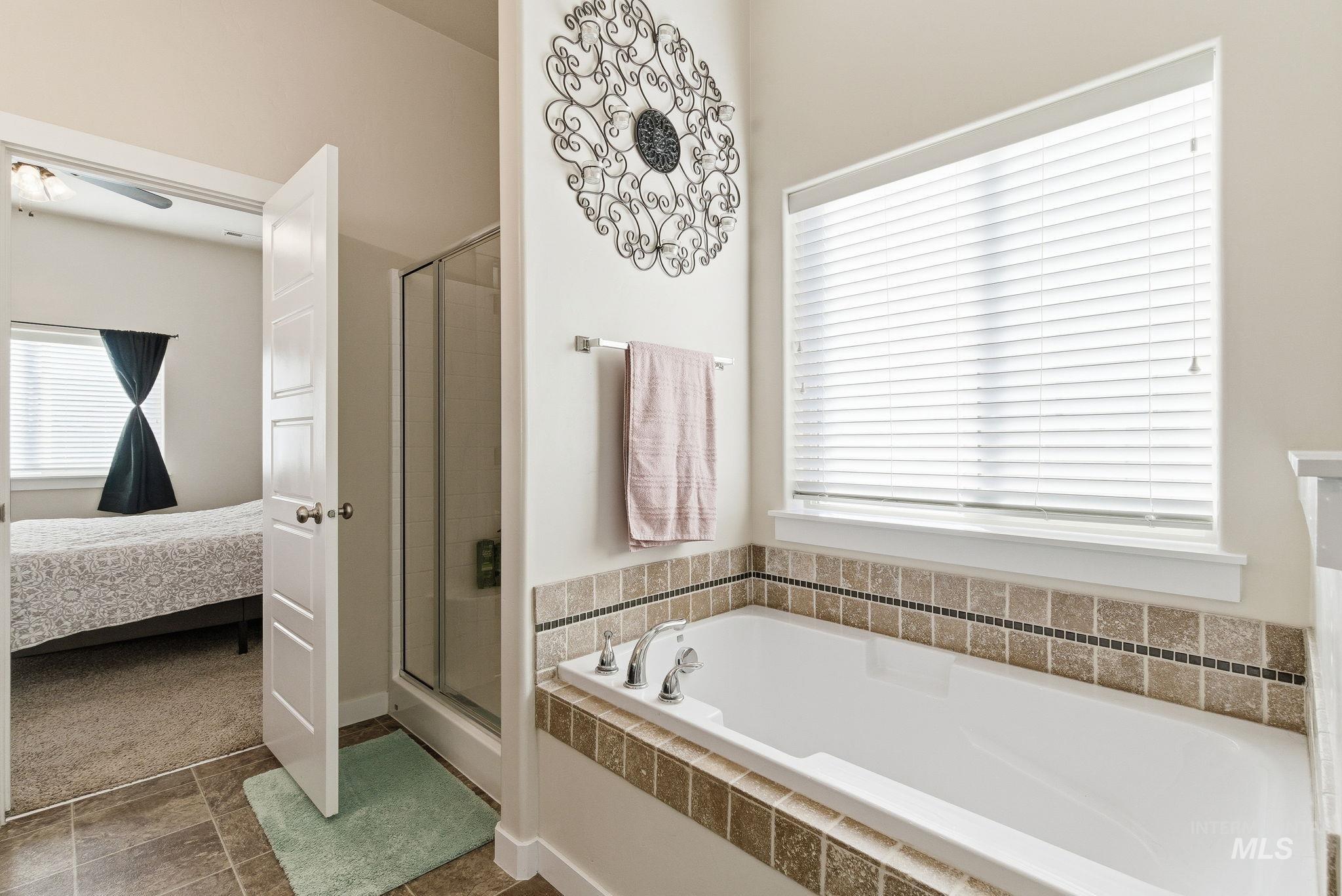 Bathroom featuring a bath, a shower stall, and connected bathroom