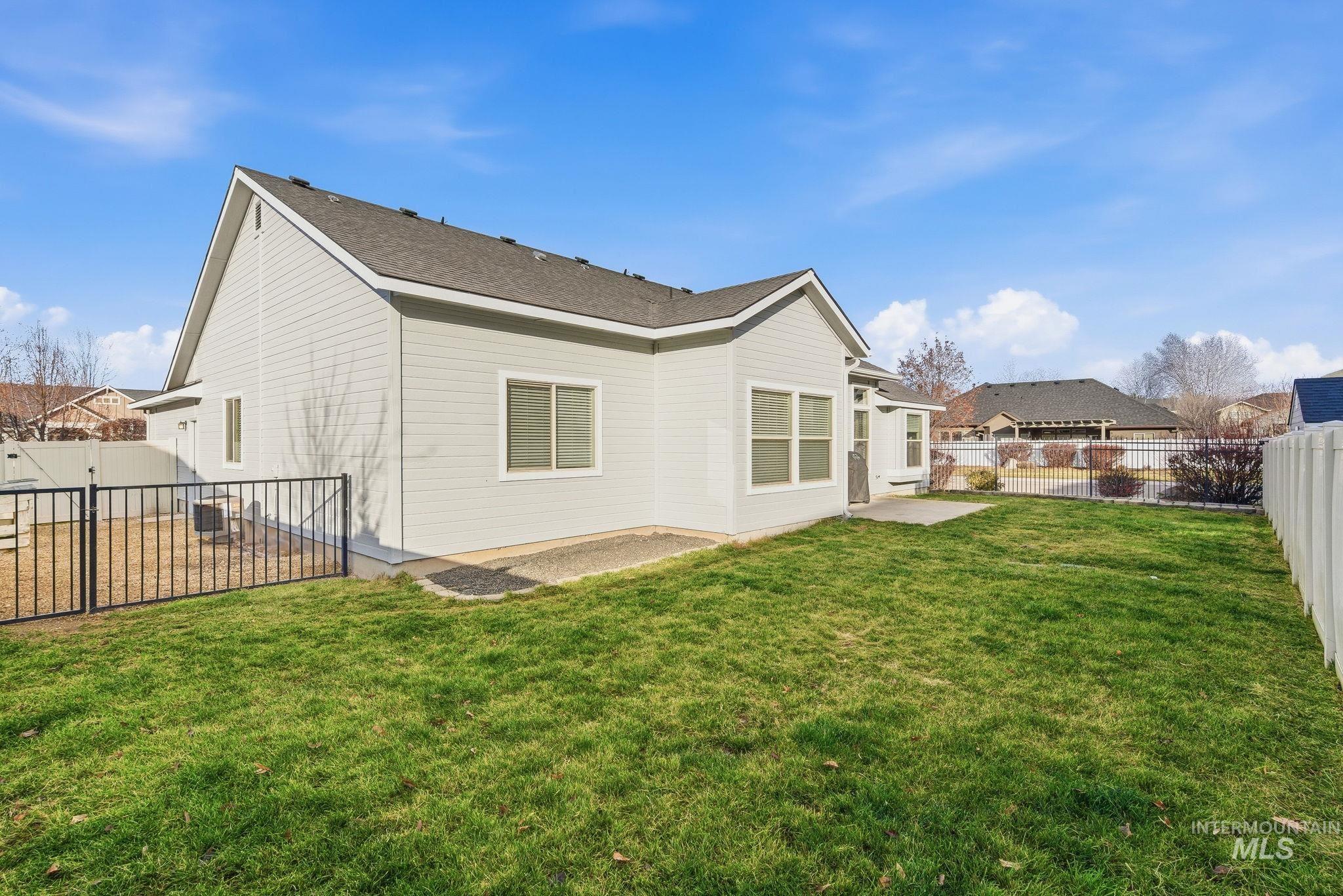 Rear view of house featuring a fenced backyard and a patio area