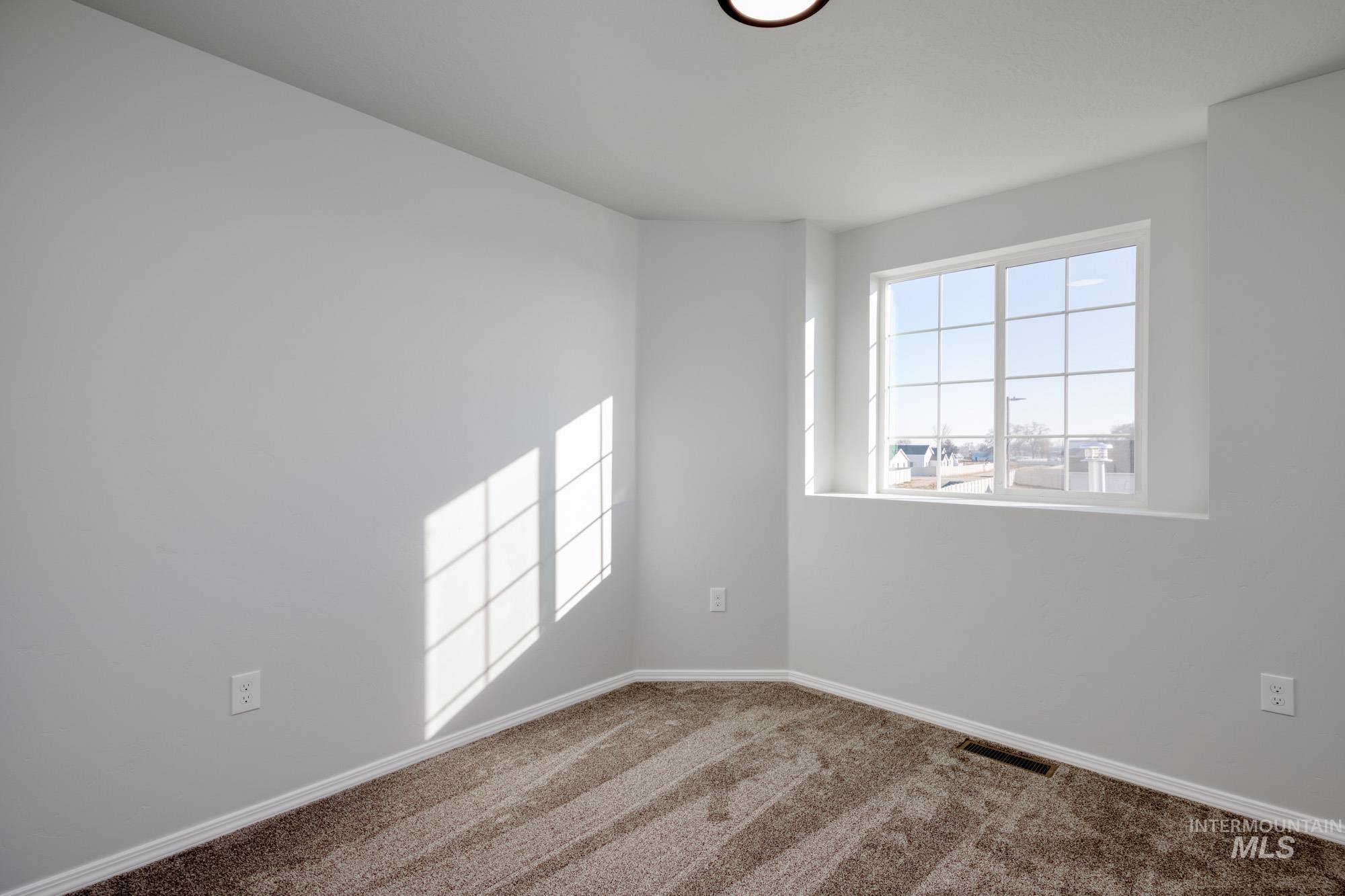 Carpeted empty room with baseboards