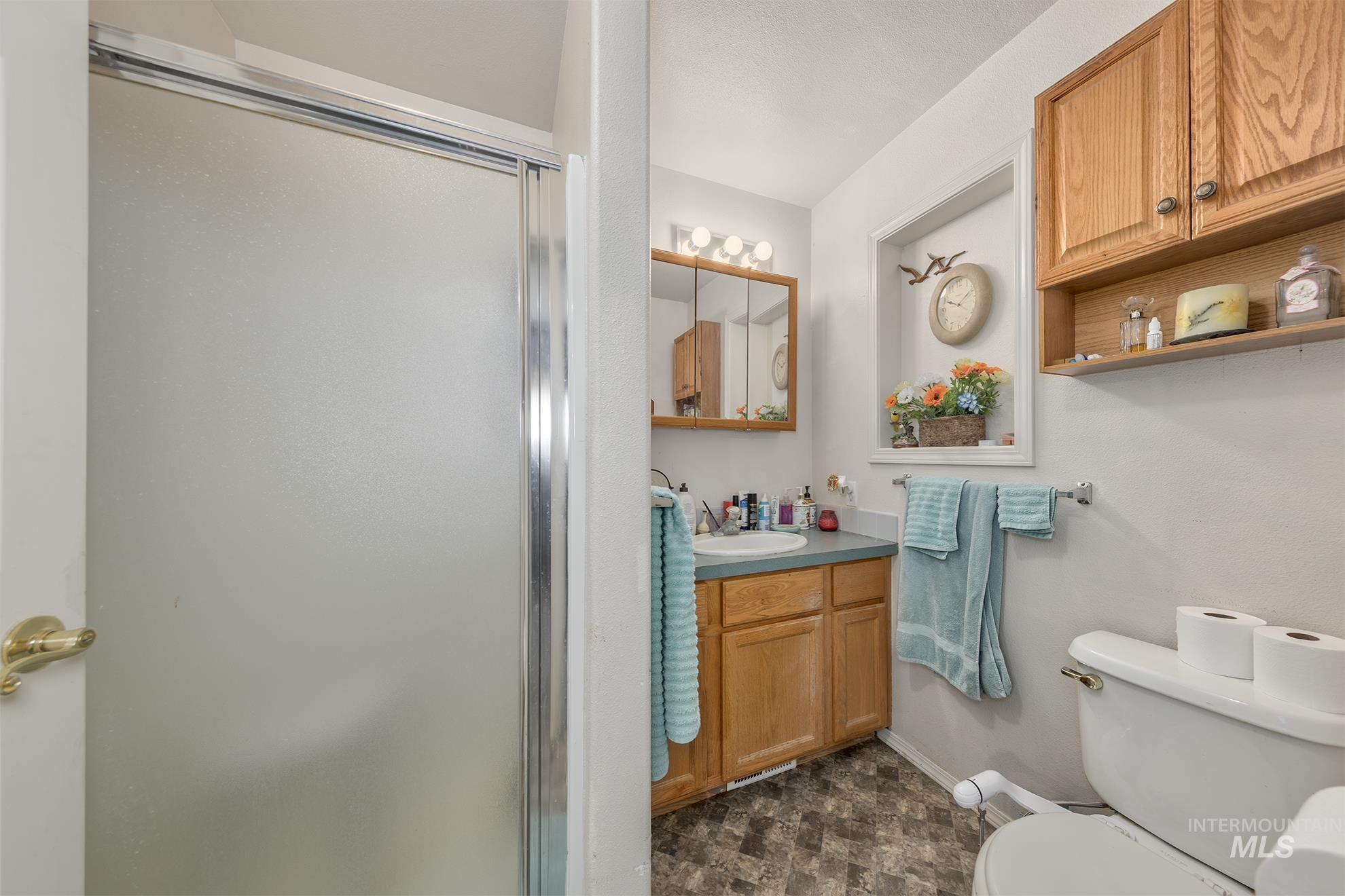 Bathroom featuring a shower stall and vanity