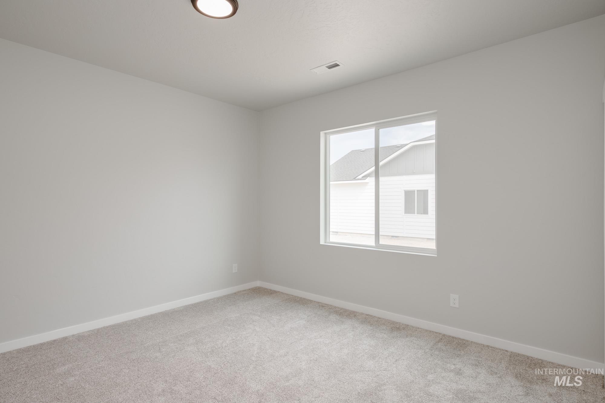 Unfurnished room featuring baseboards and light carpet