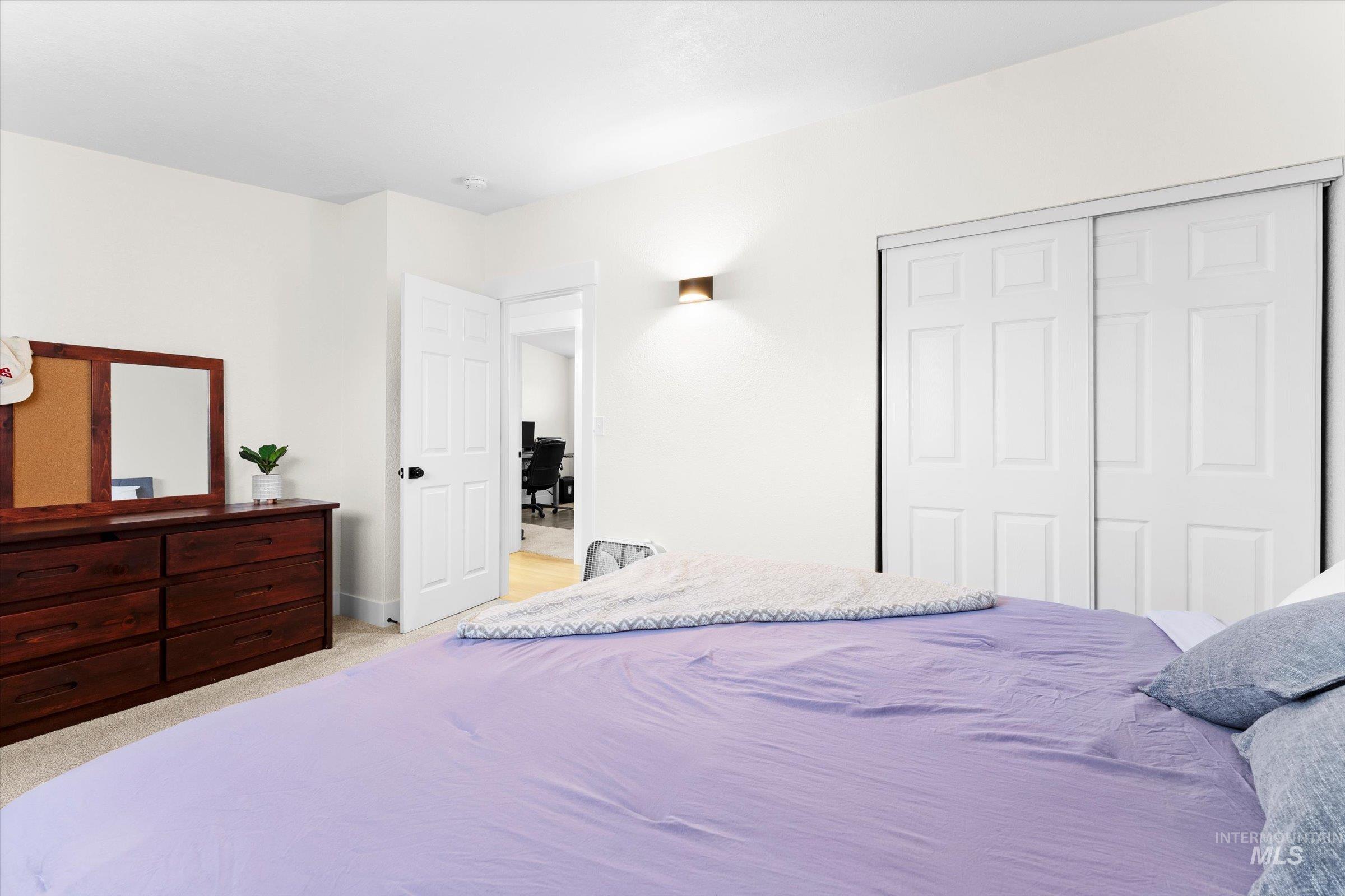 Bedroom featuring light colored carpet and a closet