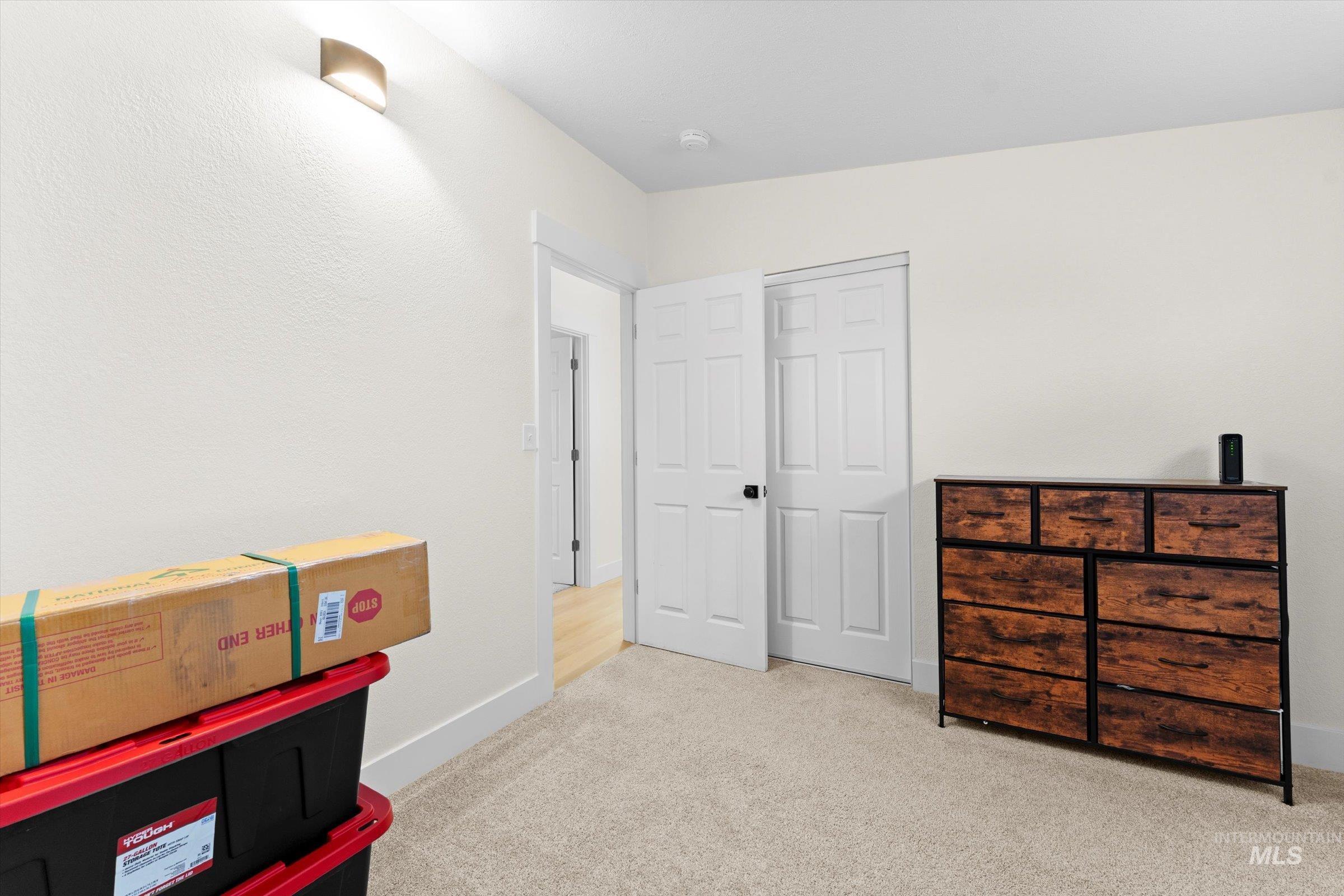 bedroom with light carpet and baseboards