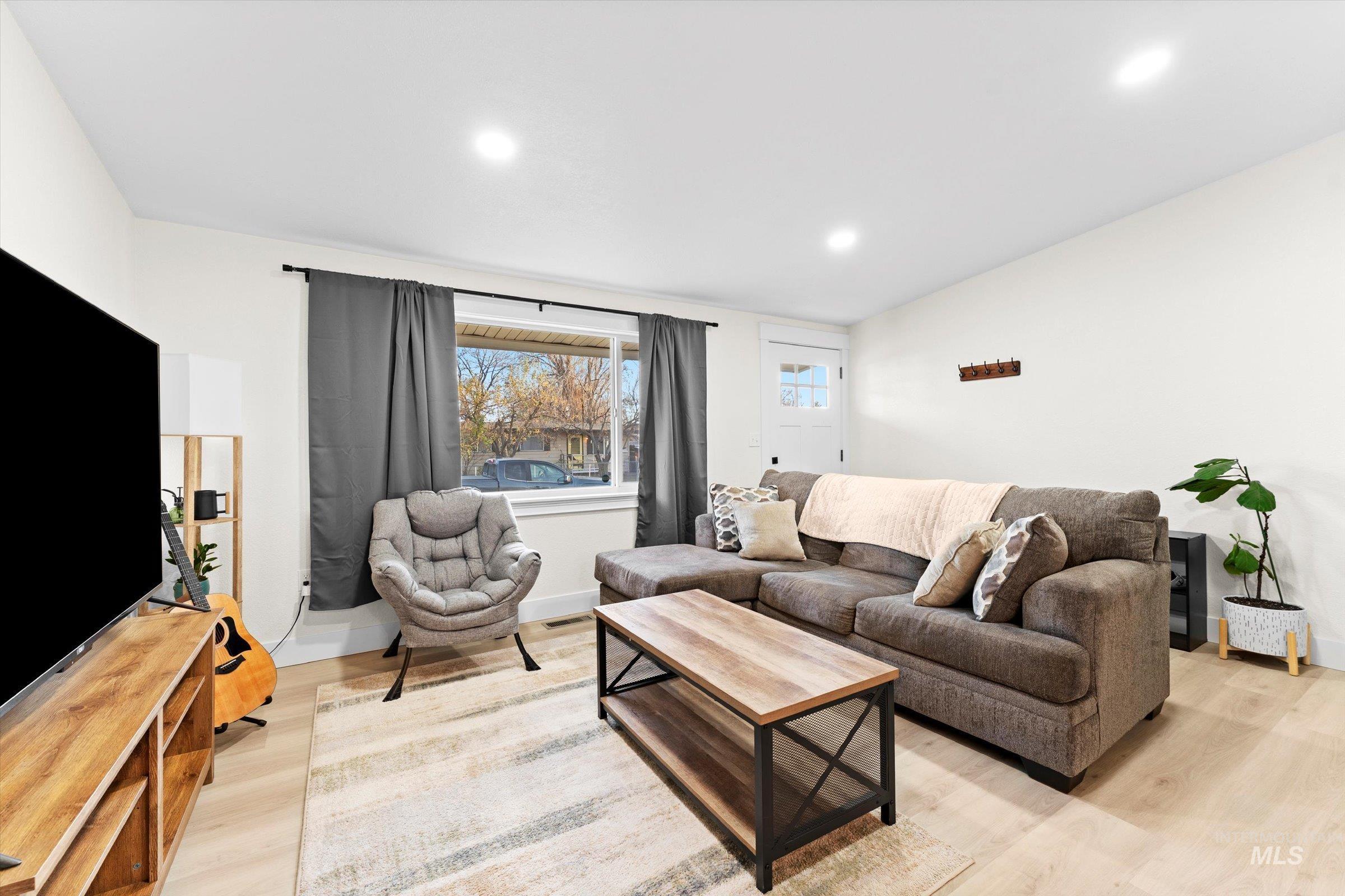 Living room featuring light wood finished floors and recessed lighting