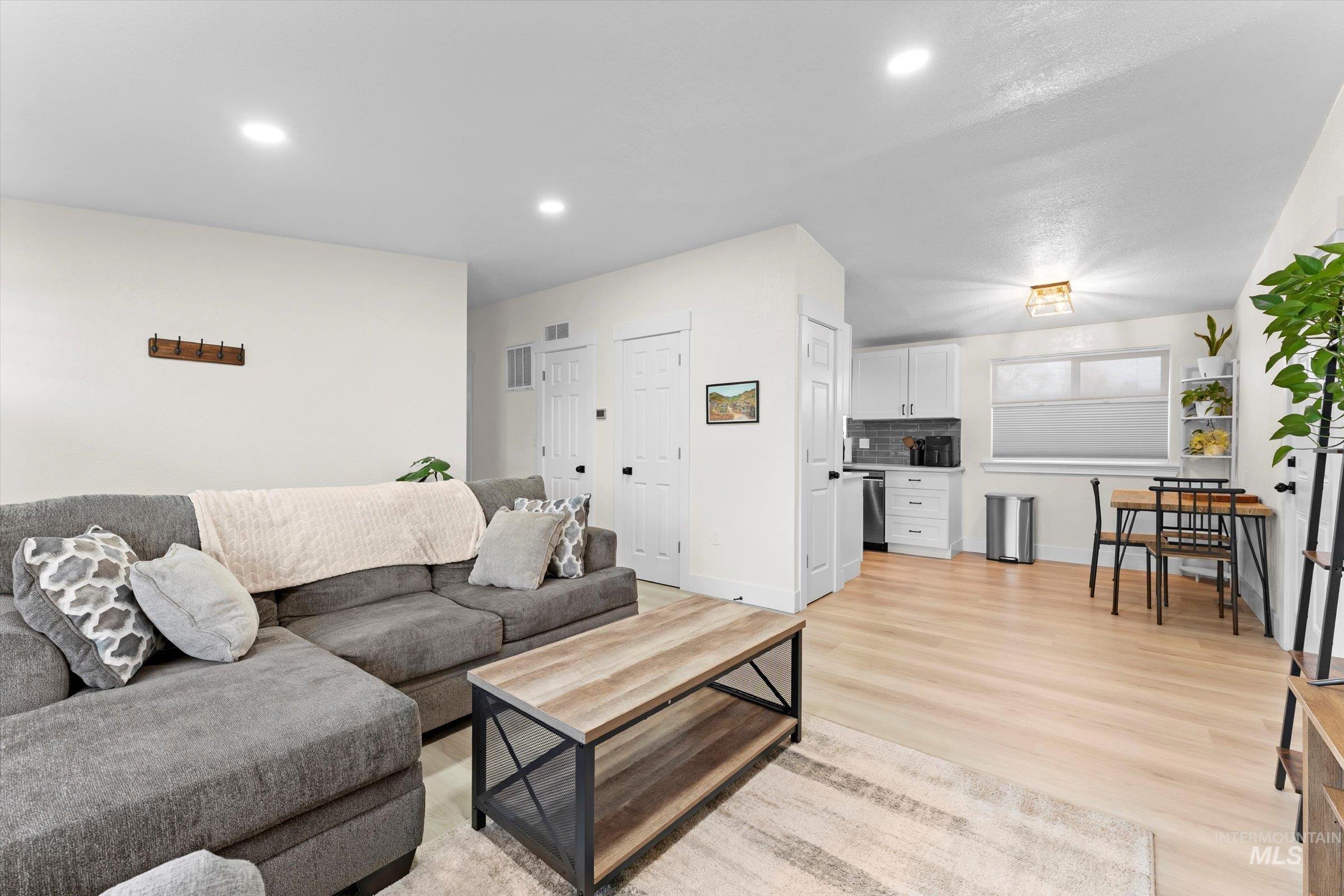 Living room with light wood finished floors and recessed lighting
