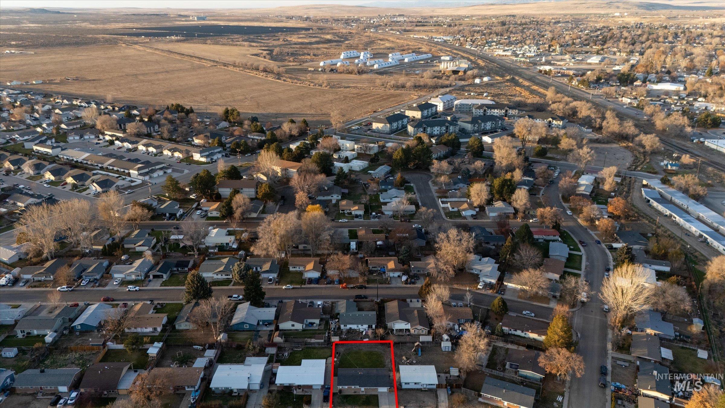 Aerial overview of property's location featuring nearby suburban area and property parcel outlined