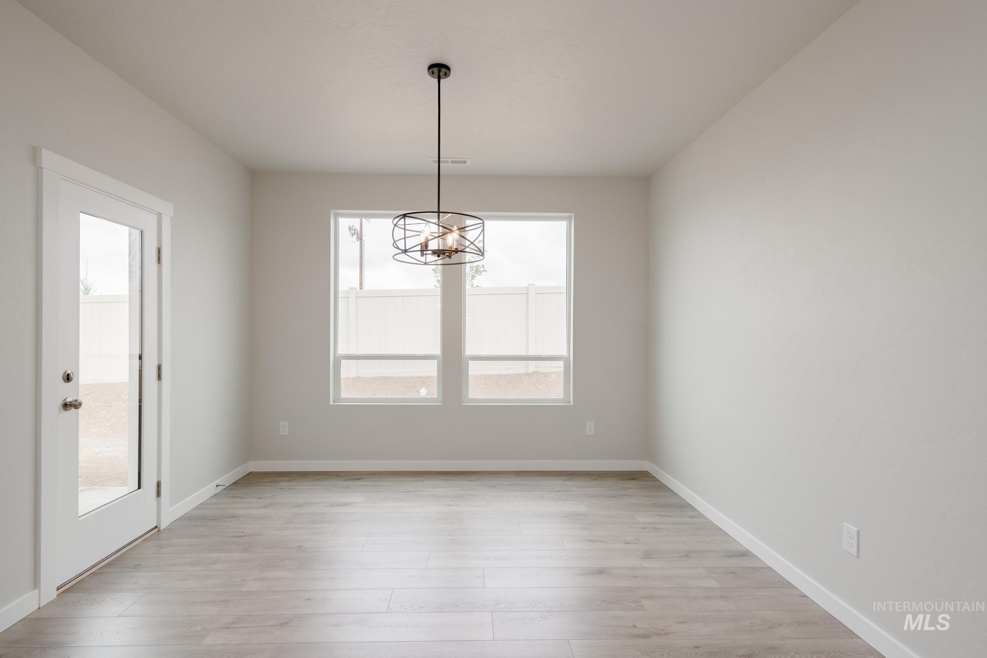Unfurnished dining area with light wood-style flooring and a chandelier