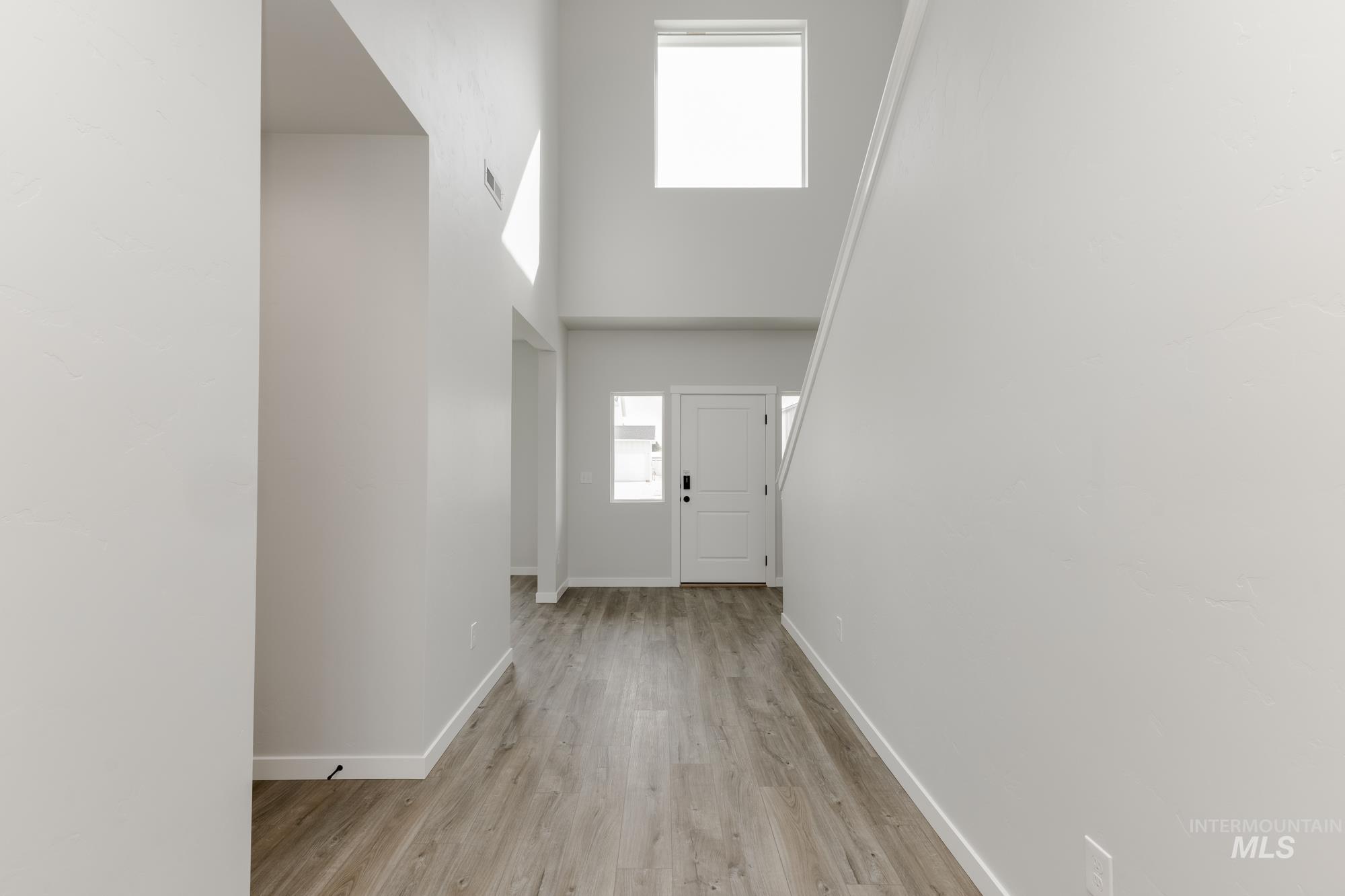 Entryway with a towering ceiling and wood finished floors