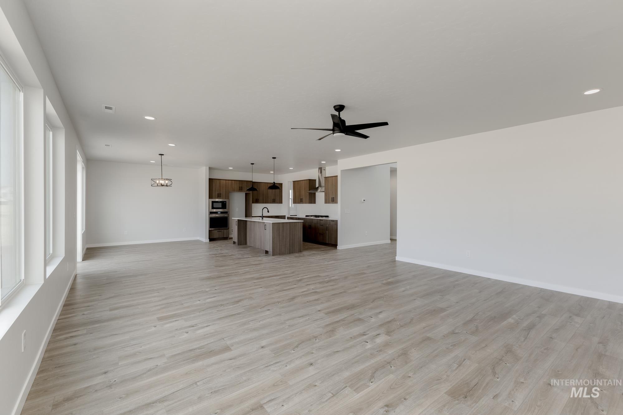 Unfurnished living room featuring recessed lighting, light wood-style flooring, and a ceiling fan