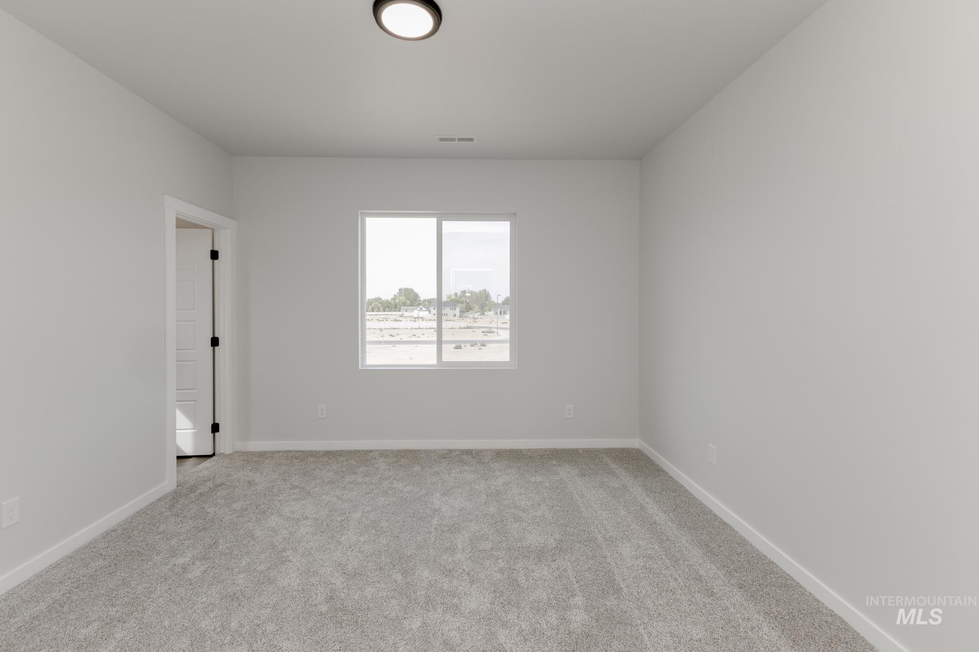 Unfurnished room featuring light colored carpet and baseboards