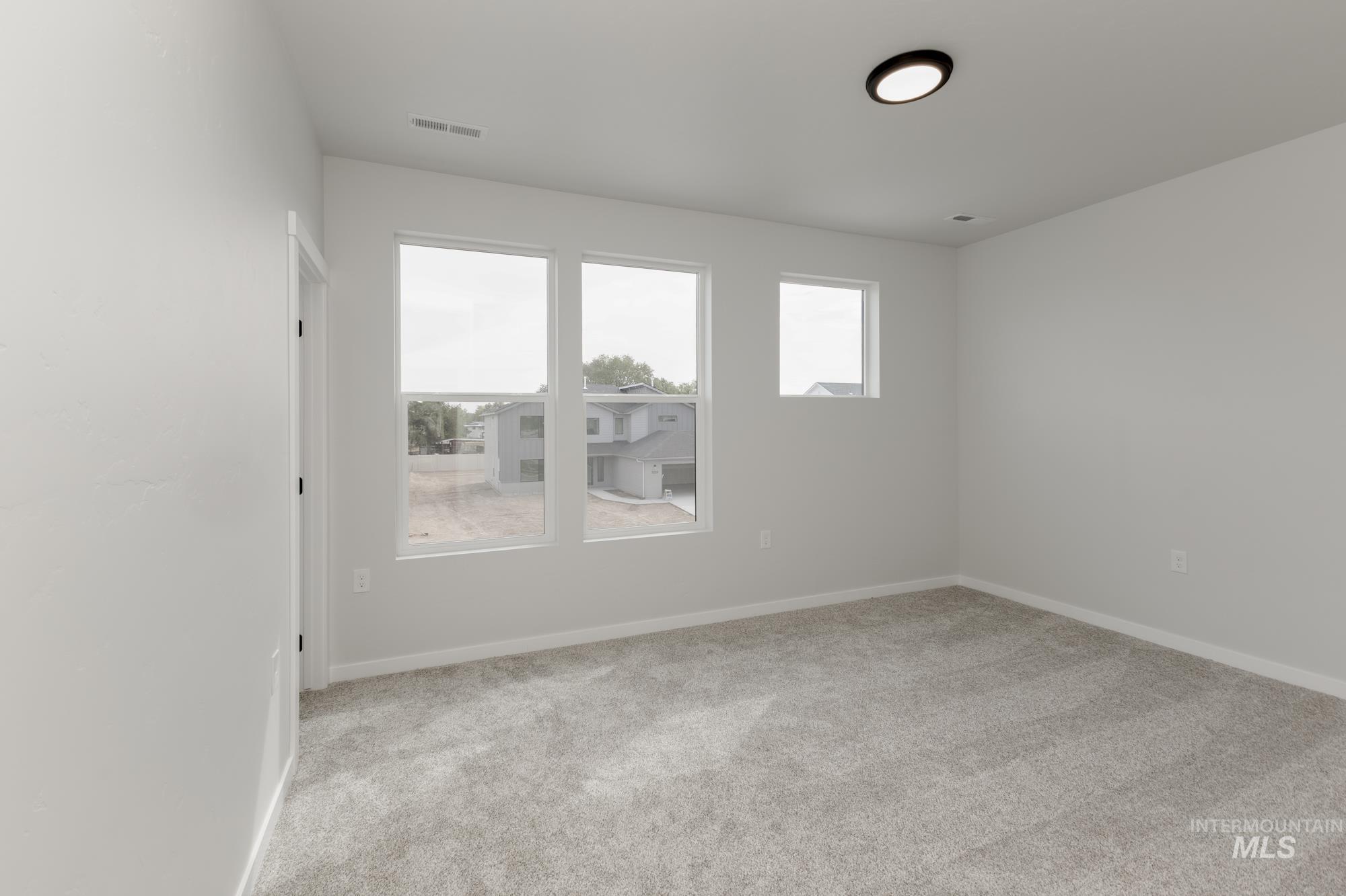Spare room with light colored carpet and baseboards