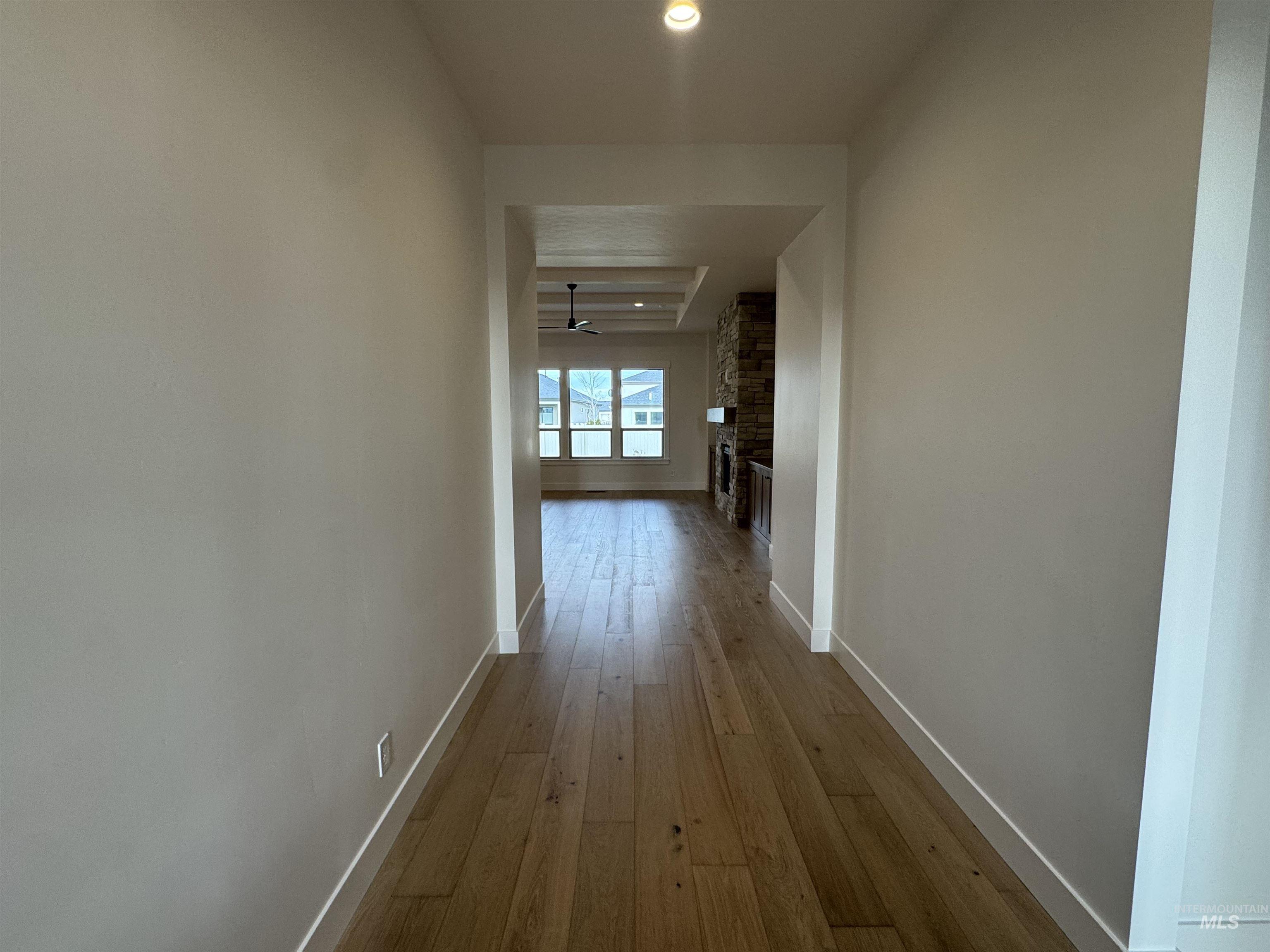Hall with baseboards and wood-type flooring