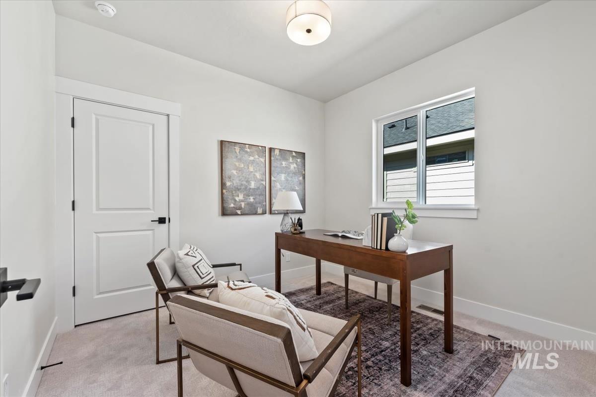 Home office with light colored carpet and baseboards