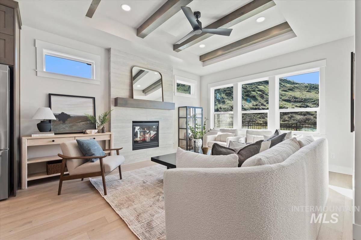 Living area featuring light wood-style flooring, a high end fireplace, healthy amount of natural light, a ceiling fan, and recessed lighting
