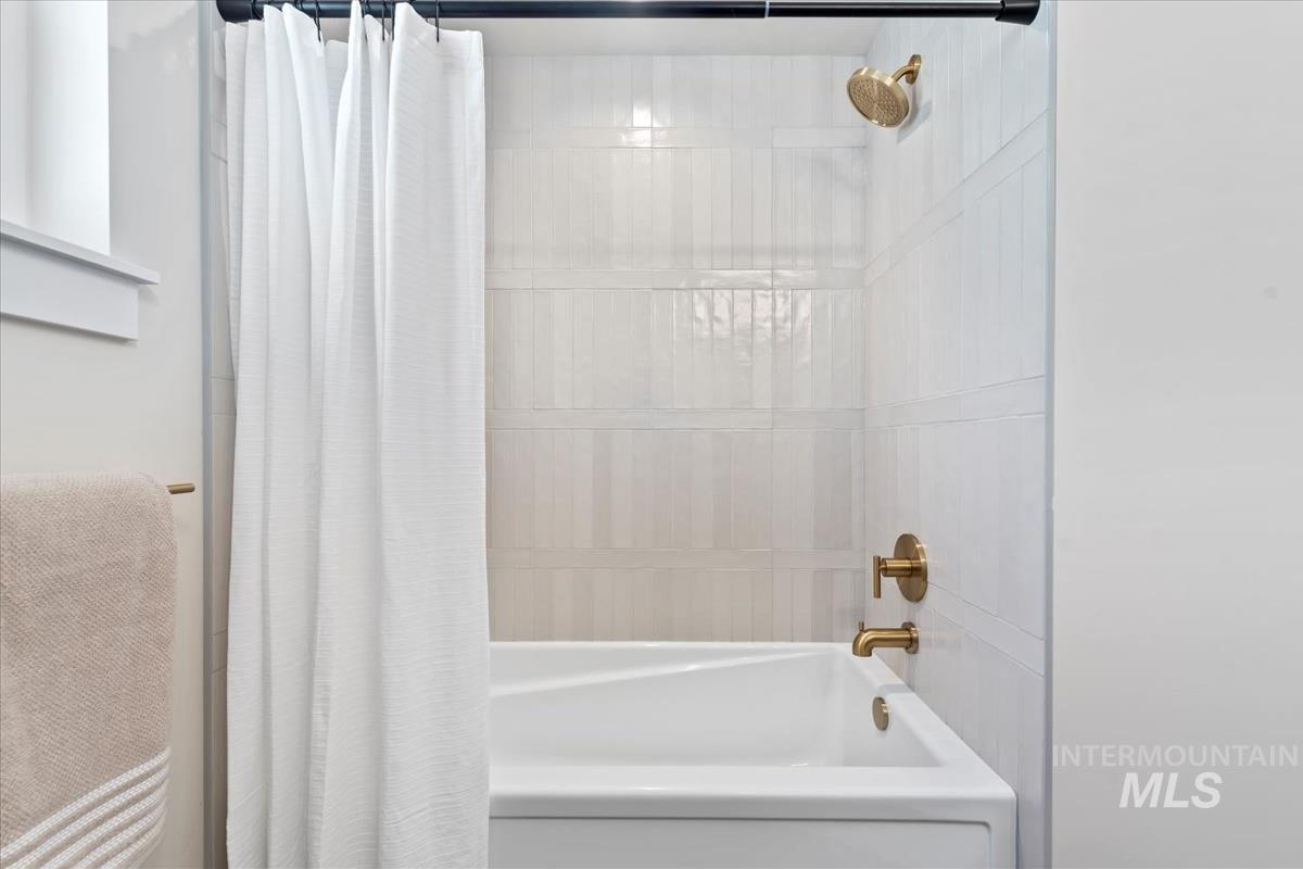 Full bath featuring shower / bath combo with shower curtain