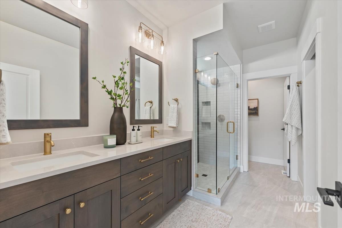Bathroom with double vanity and a shower stall