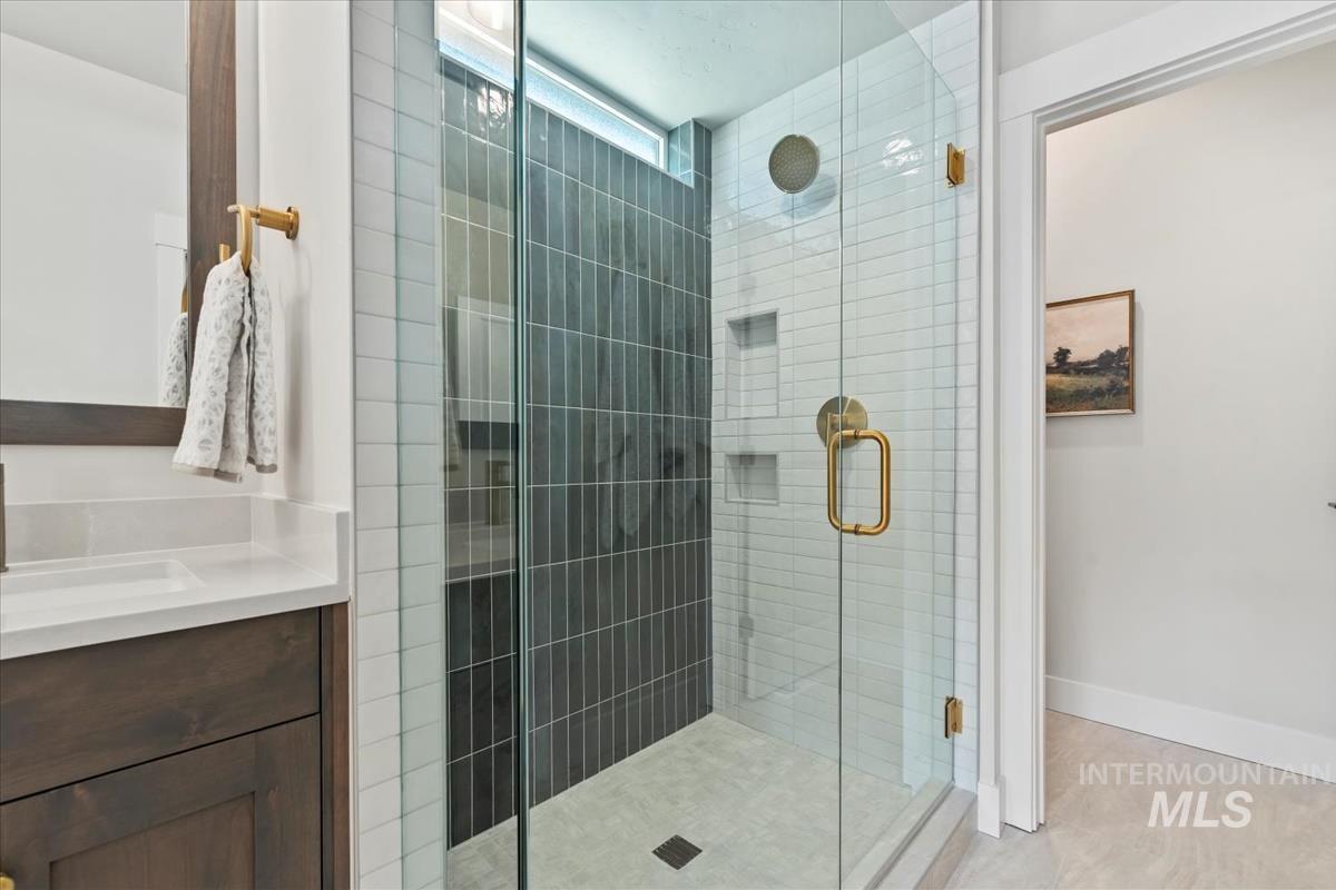 Full bath featuring a stall shower and vanity