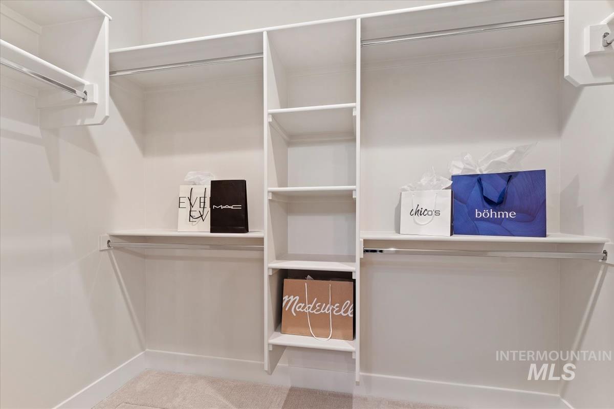 Walk in closet featuring light carpet