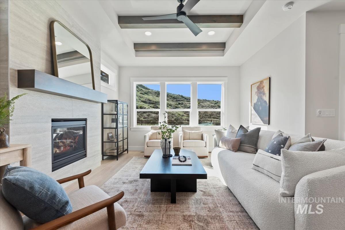 Living area featuring a tiled fireplace, wood finished floors, recessed lighting, and a ceiling fan
