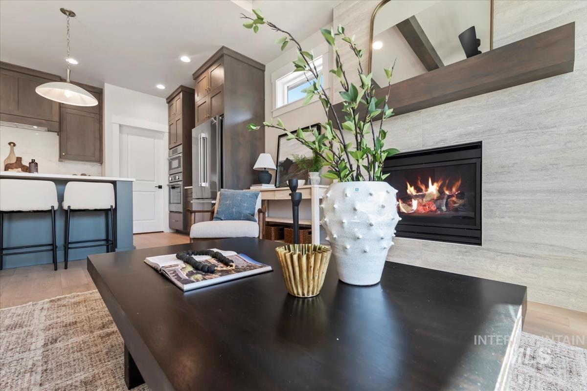Dining room with light wood-type flooring, recessed lighting, and a tiled fireplace