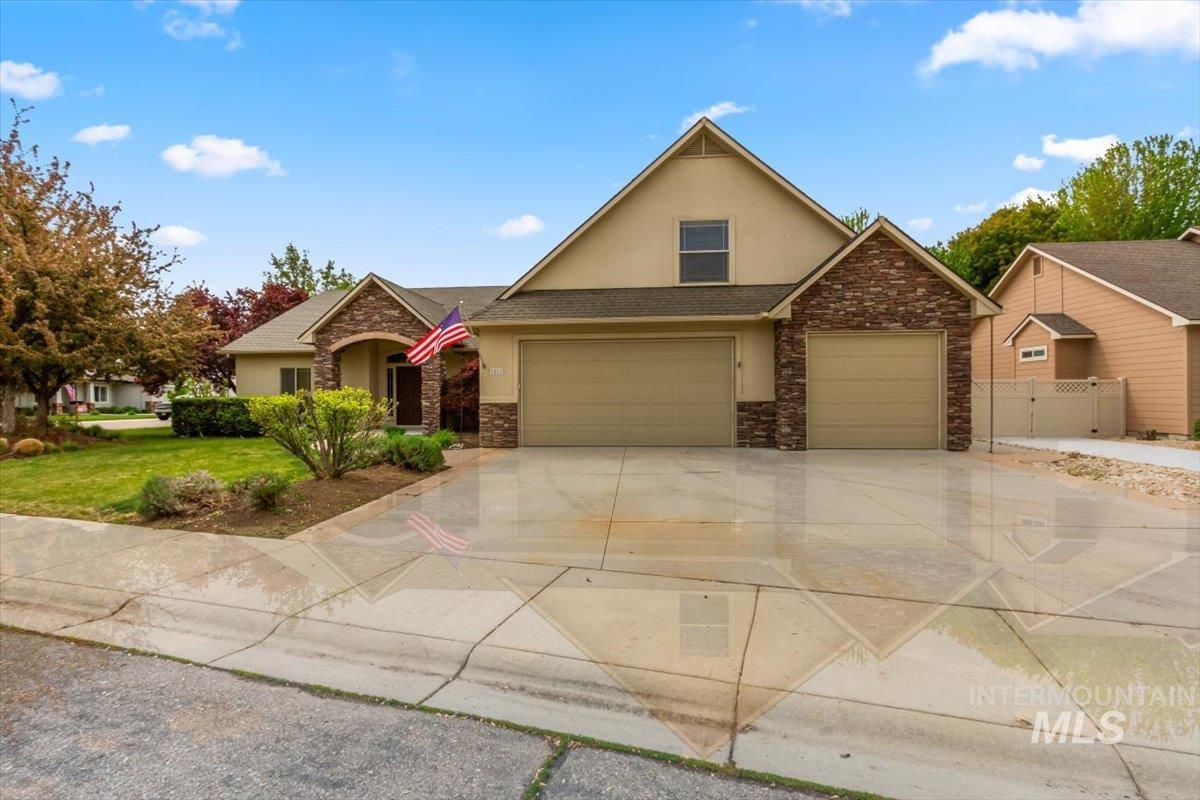 View of front of house featuring stucco siding, driveway, a shingled roof, and stone siding