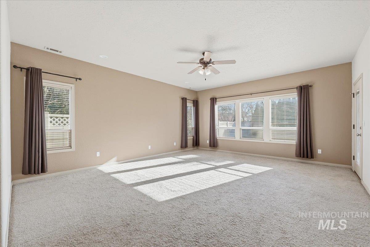 Unfurnished room with carpet floors, ceiling fan, and a textured ceiling