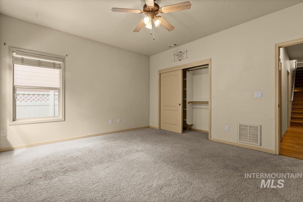 Unfurnished bedroom featuring a closet, carpet, a ceiling fan, and a textured ceiling