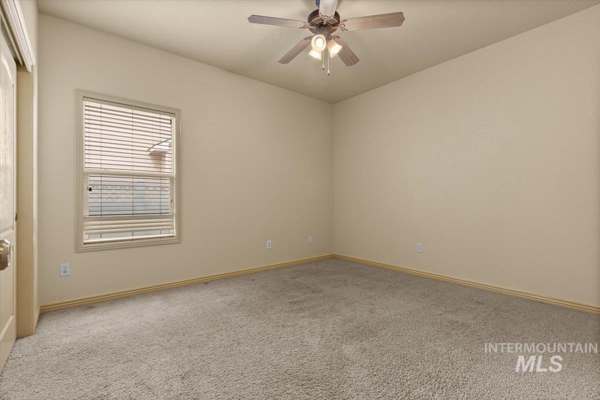 Empty room with carpet and ceiling fan