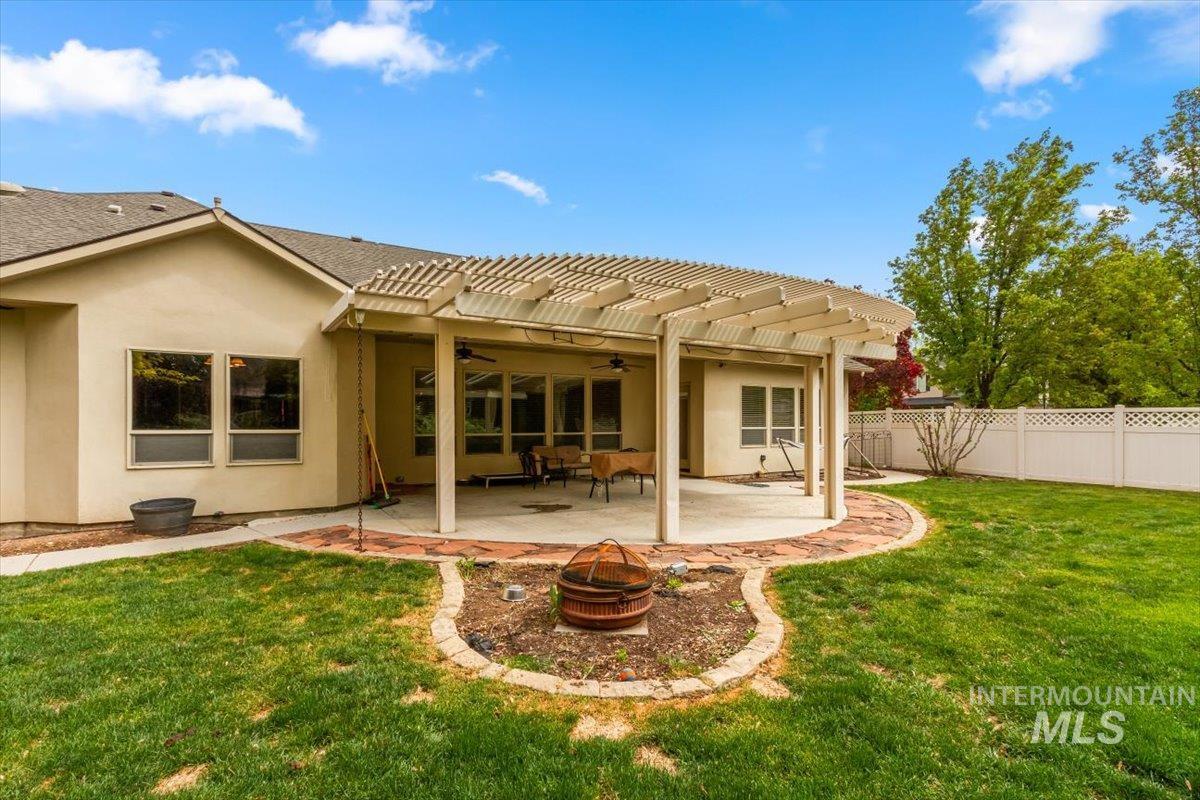 Back of house with a pergola, a patio, stucco siding, ceiling fan, and a fenced backyard