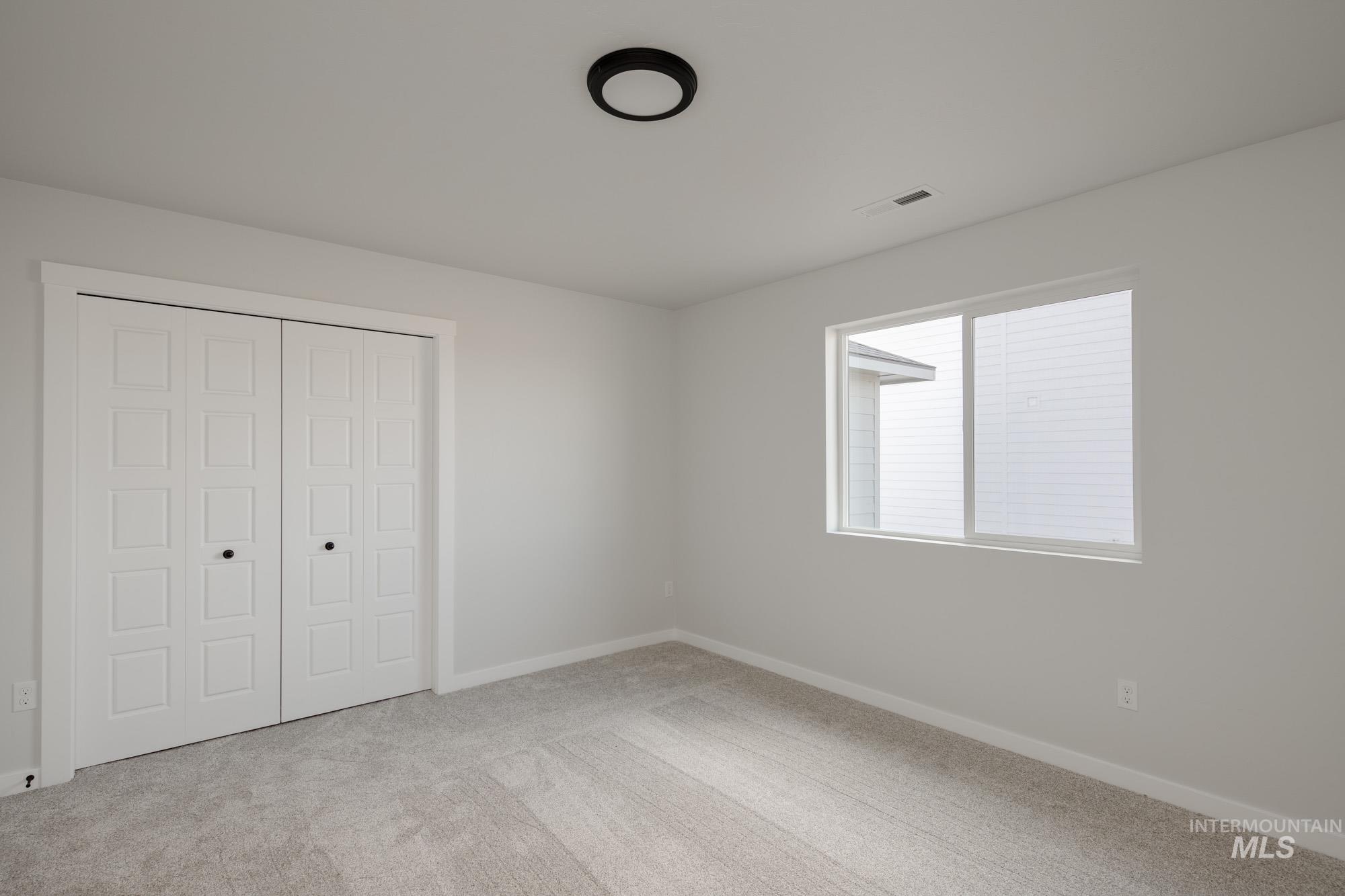 Unfurnished bedroom featuring a closet and light carpet