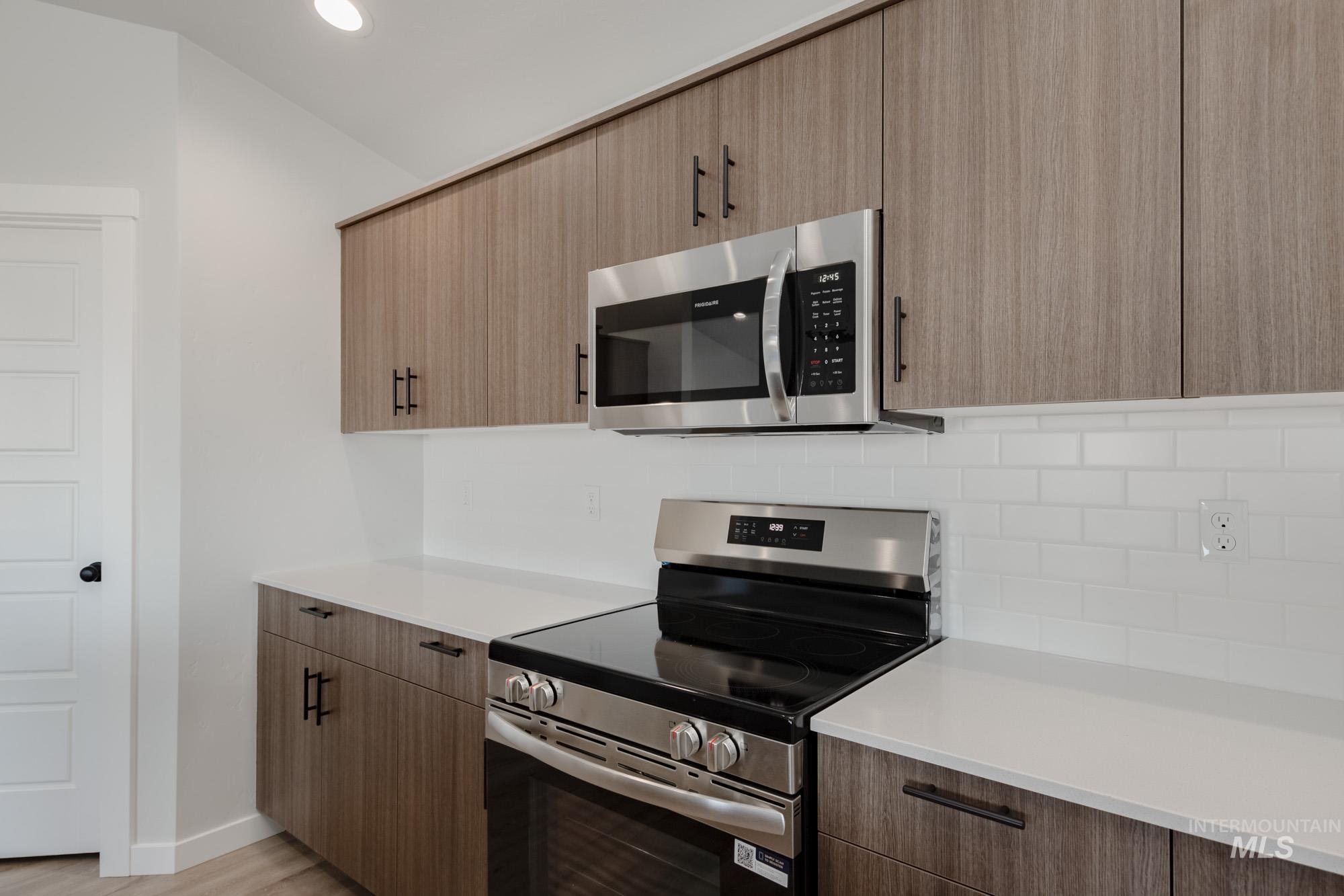 Kitchen featuring appliances with stainless steel finishes, tasteful backsplash, modern cabinets, recessed lighting, and light wood-style floors