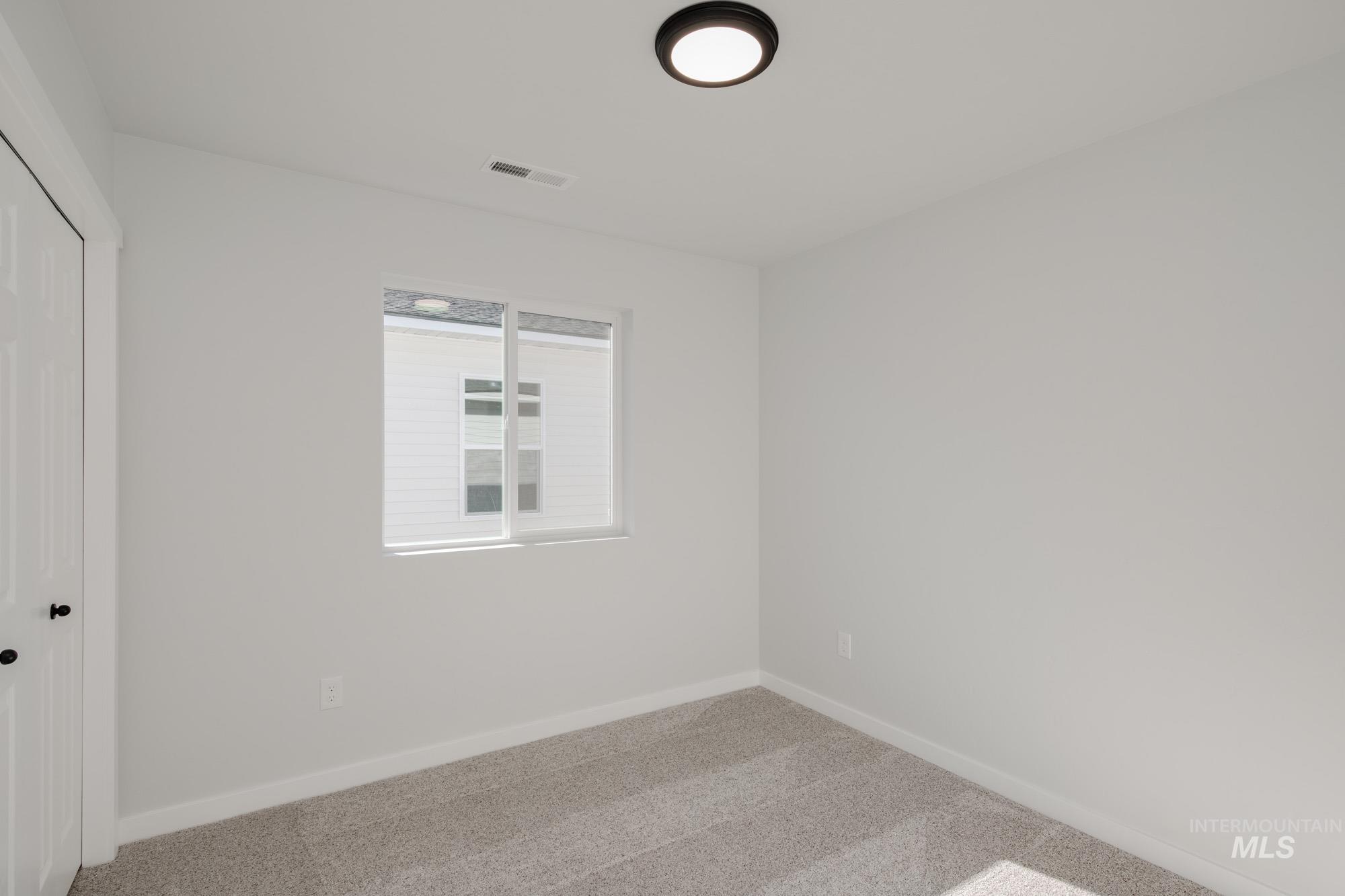 Carpeted empty room with baseboards