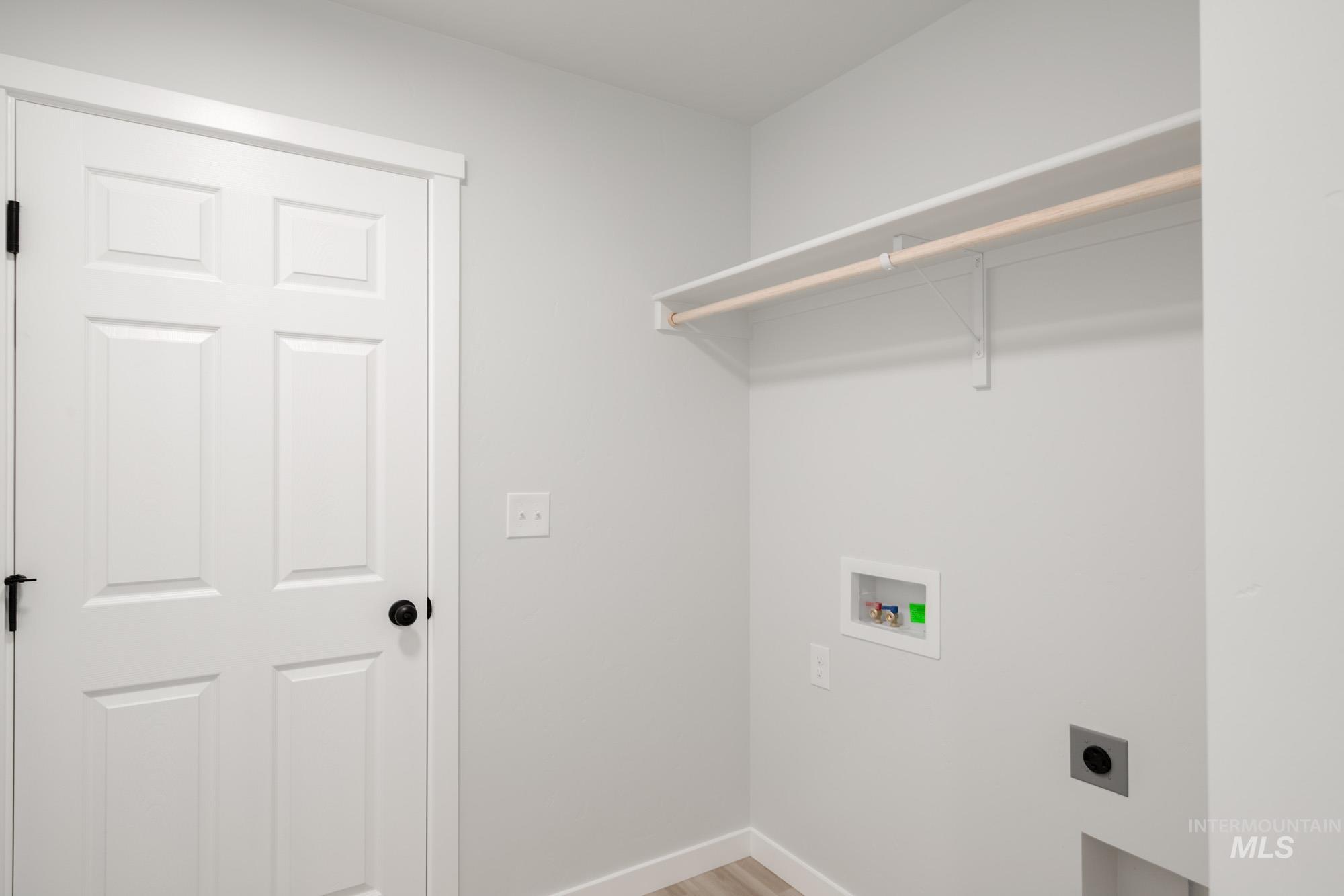 Laundry room with hookup for a washing machine, light wood-style flooring, and electric dryer hookup