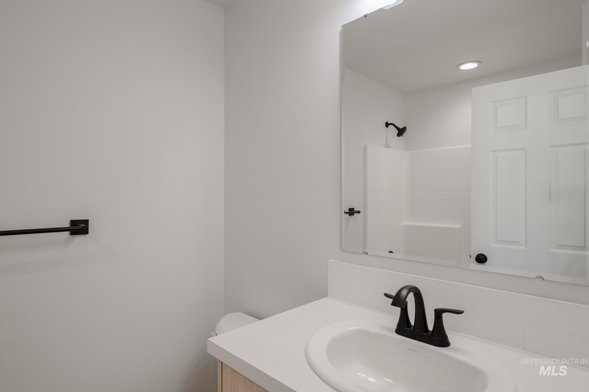 Full bathroom with vanity, a shower, and tasteful backsplash