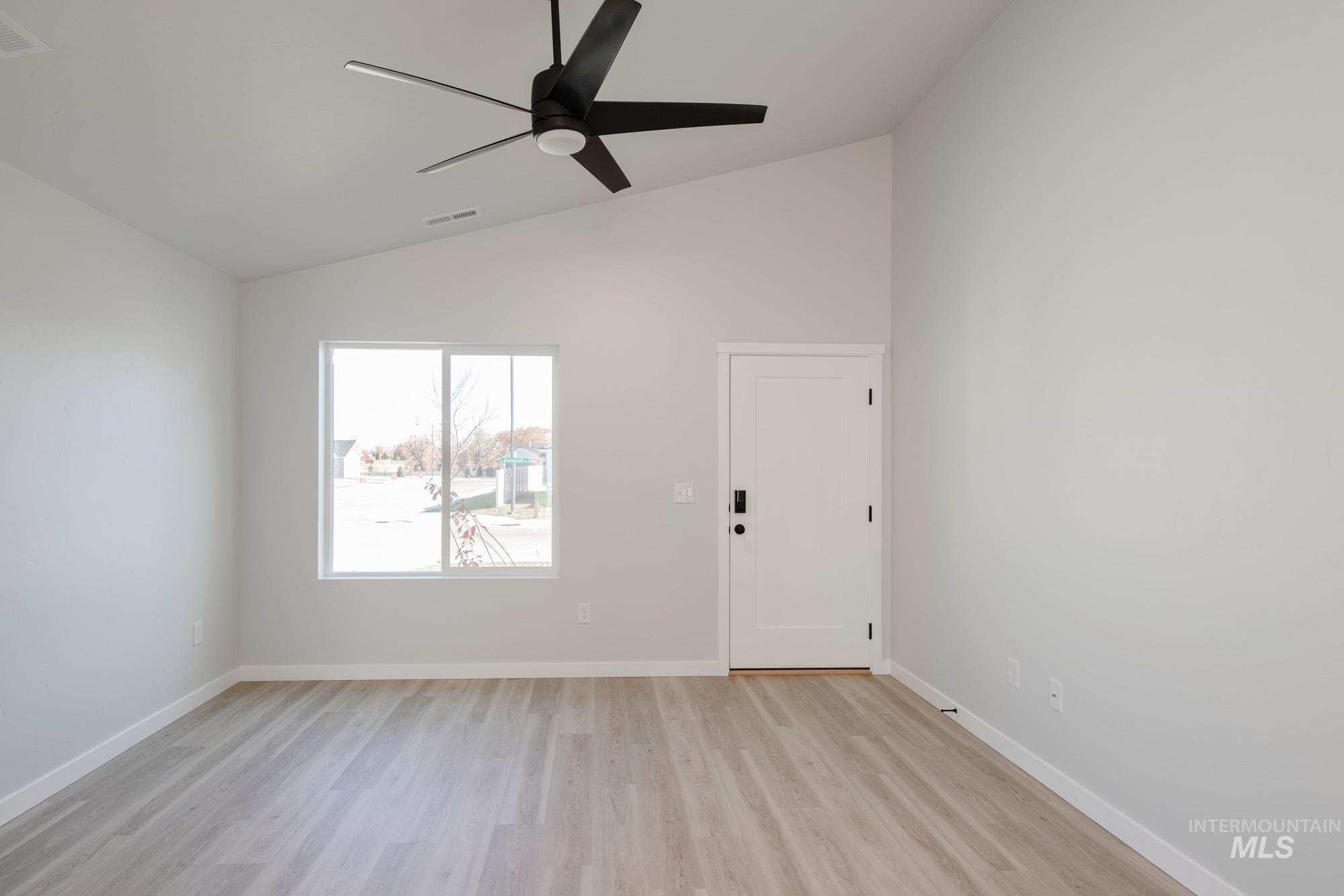 Foyer with lofted ceiling, light wood-style flooring, and ceiling fan