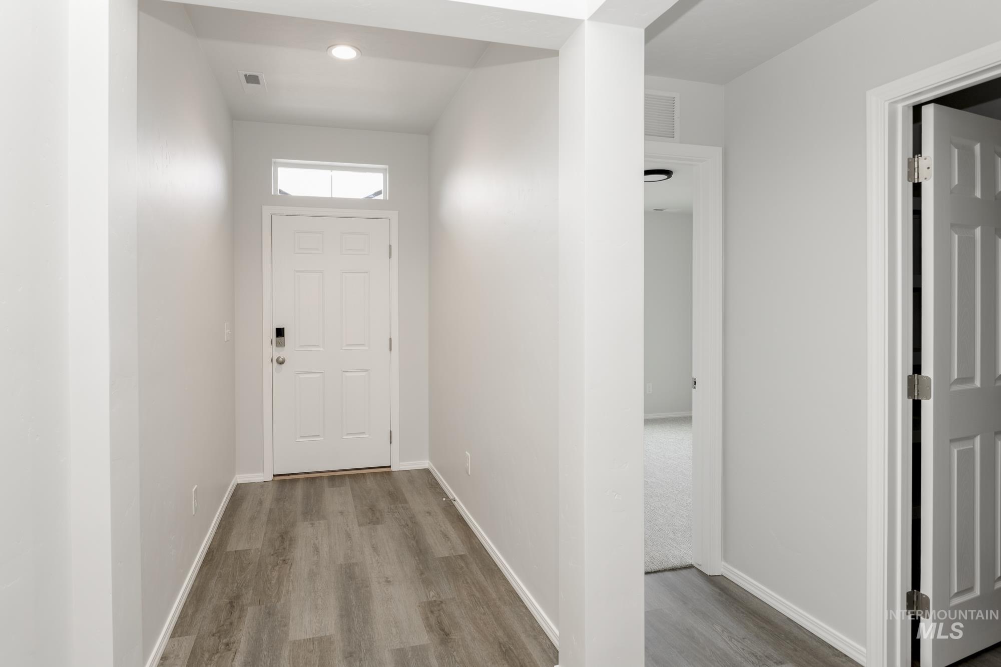 Doorway to outside with wood finished floors and baseboards