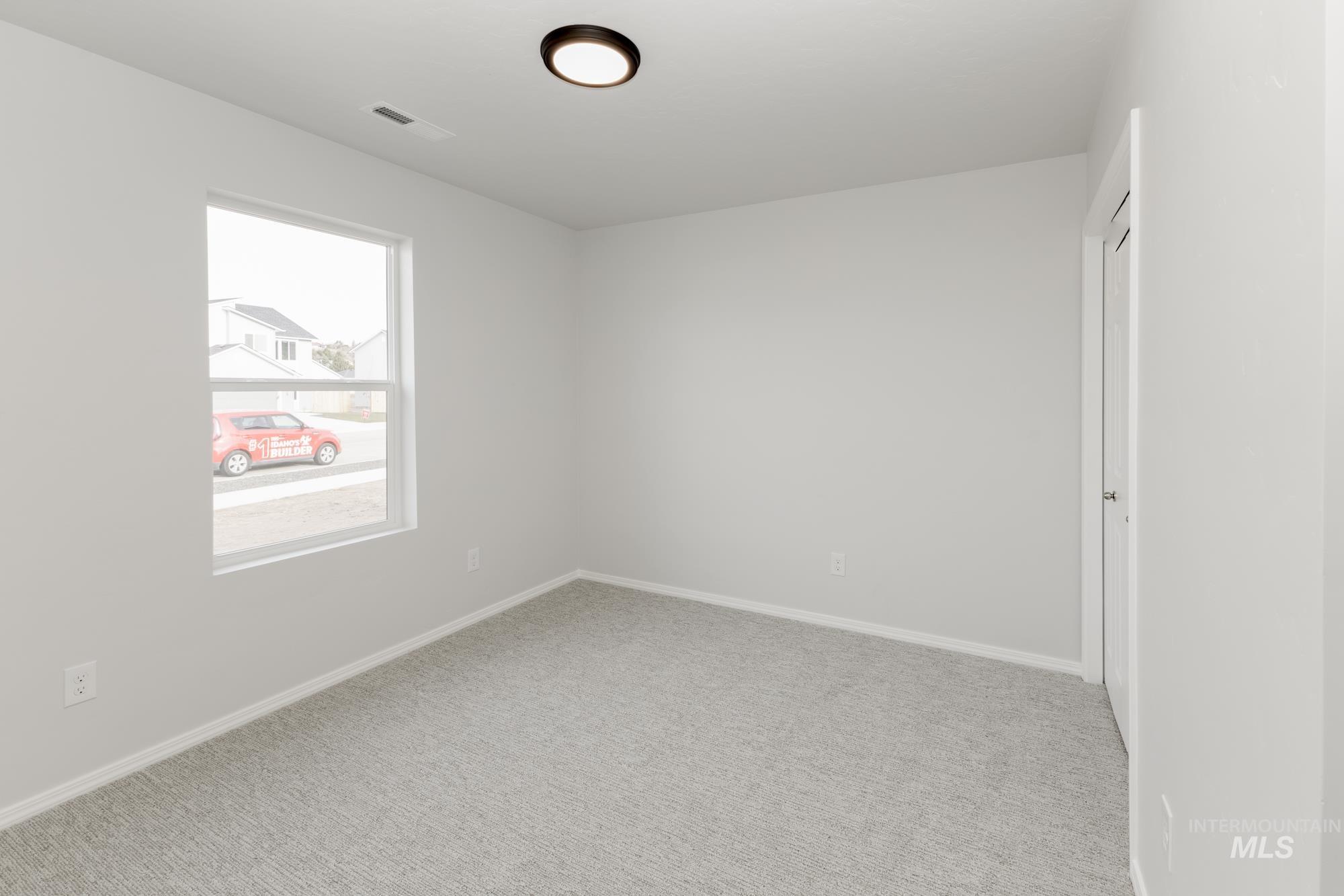 Empty room with carpet floors and baseboards