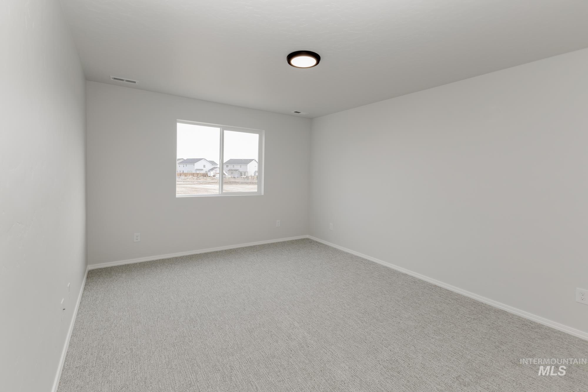 Carpeted empty room featuring baseboards