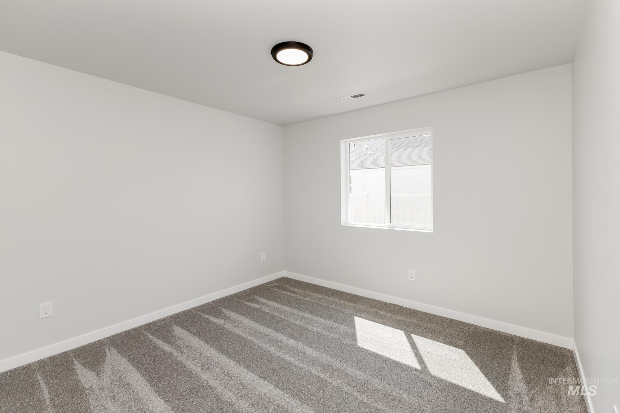 Carpeted empty room featuring baseboards