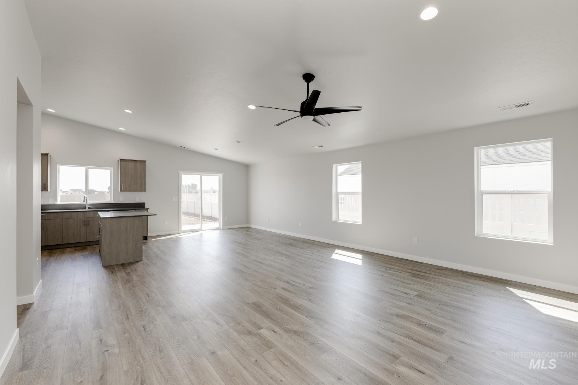 Unfurnished living room with recessed lighting, lofted ceiling, light wood finished floors, and ceiling fan