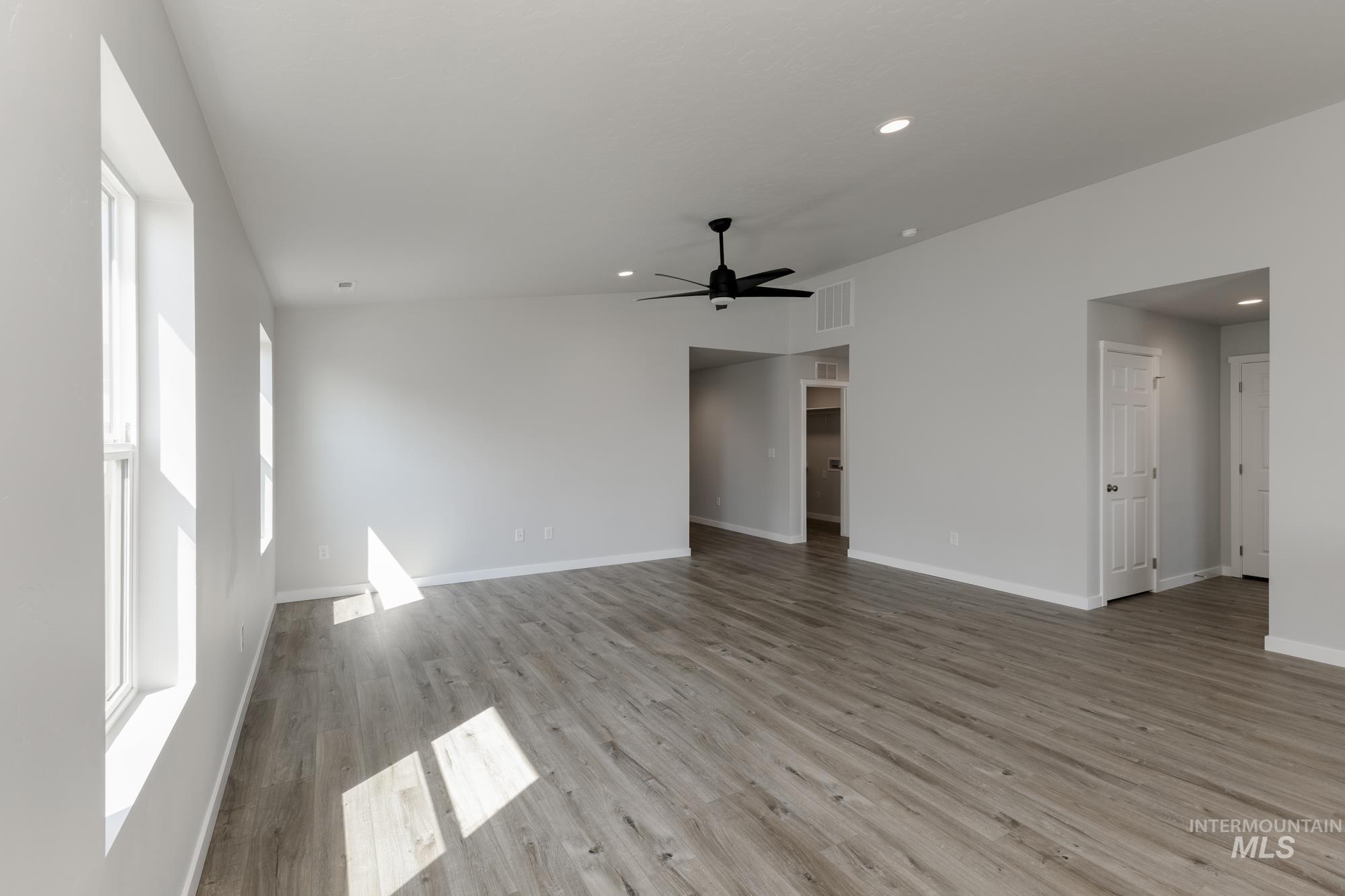Empty room featuring a ceiling fan, light wood-style floors, recessed lighting, and lofted ceiling