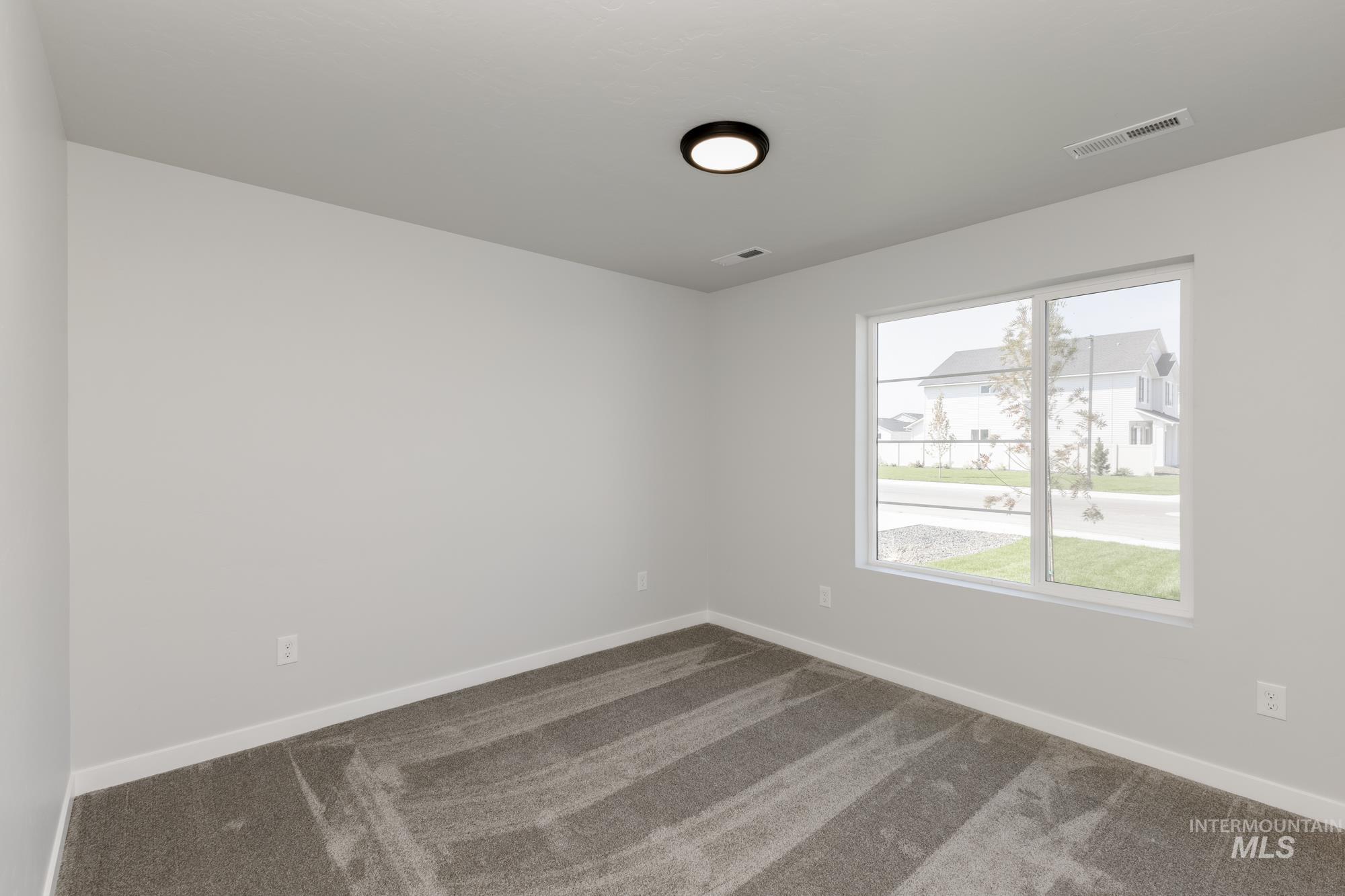 Unfurnished room with dark carpet and baseboards