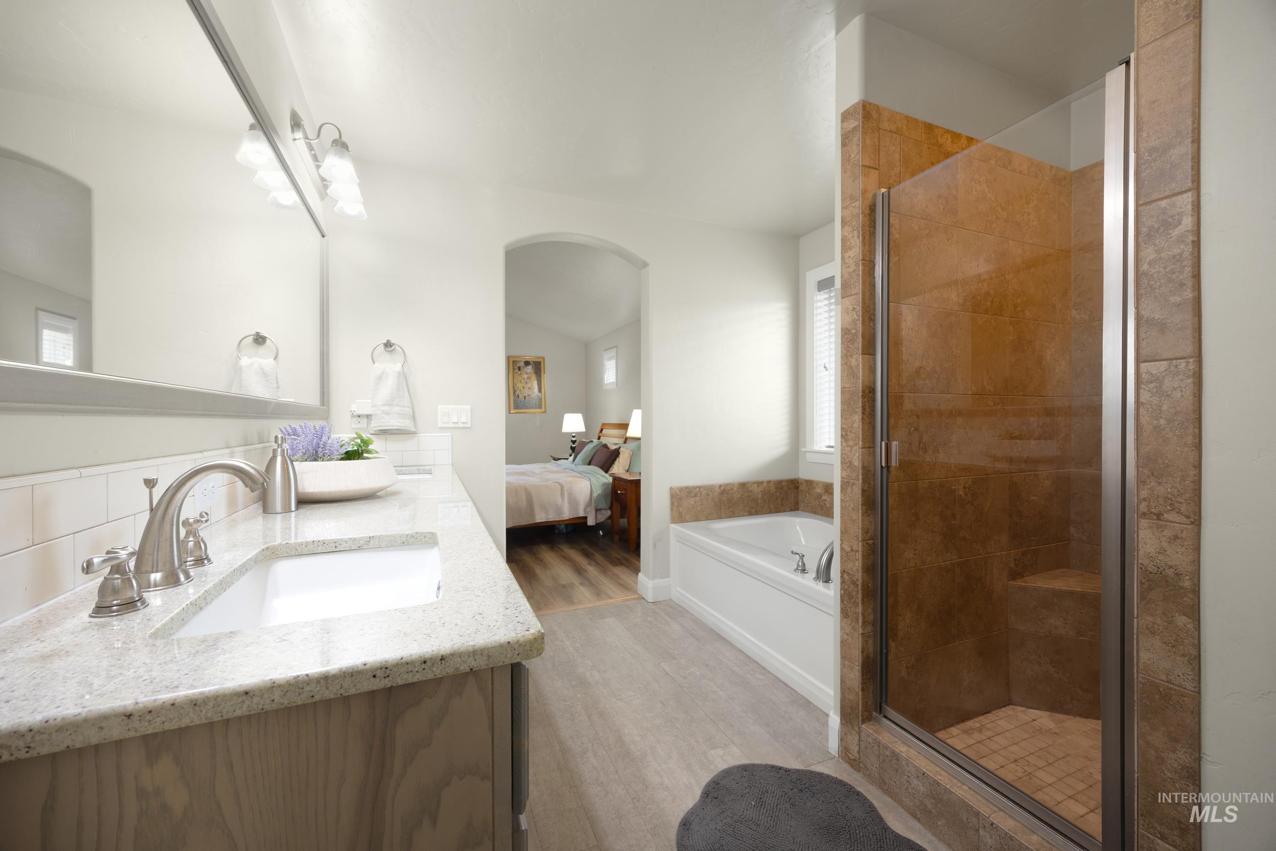 Ensuite bathroom with a bath, a shower stall, double vanity