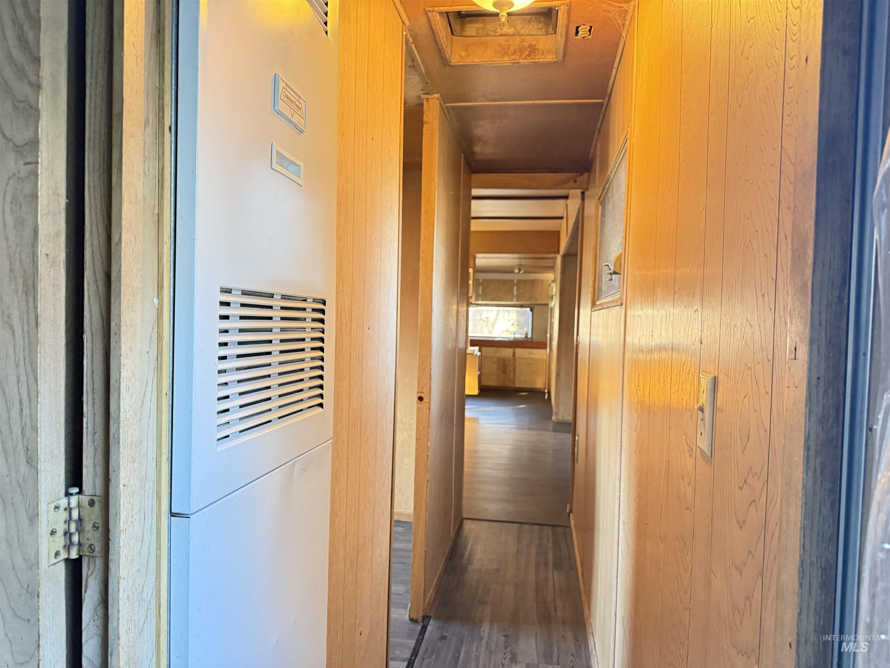 Hallway featuring a heating unit and dark wood-style floors