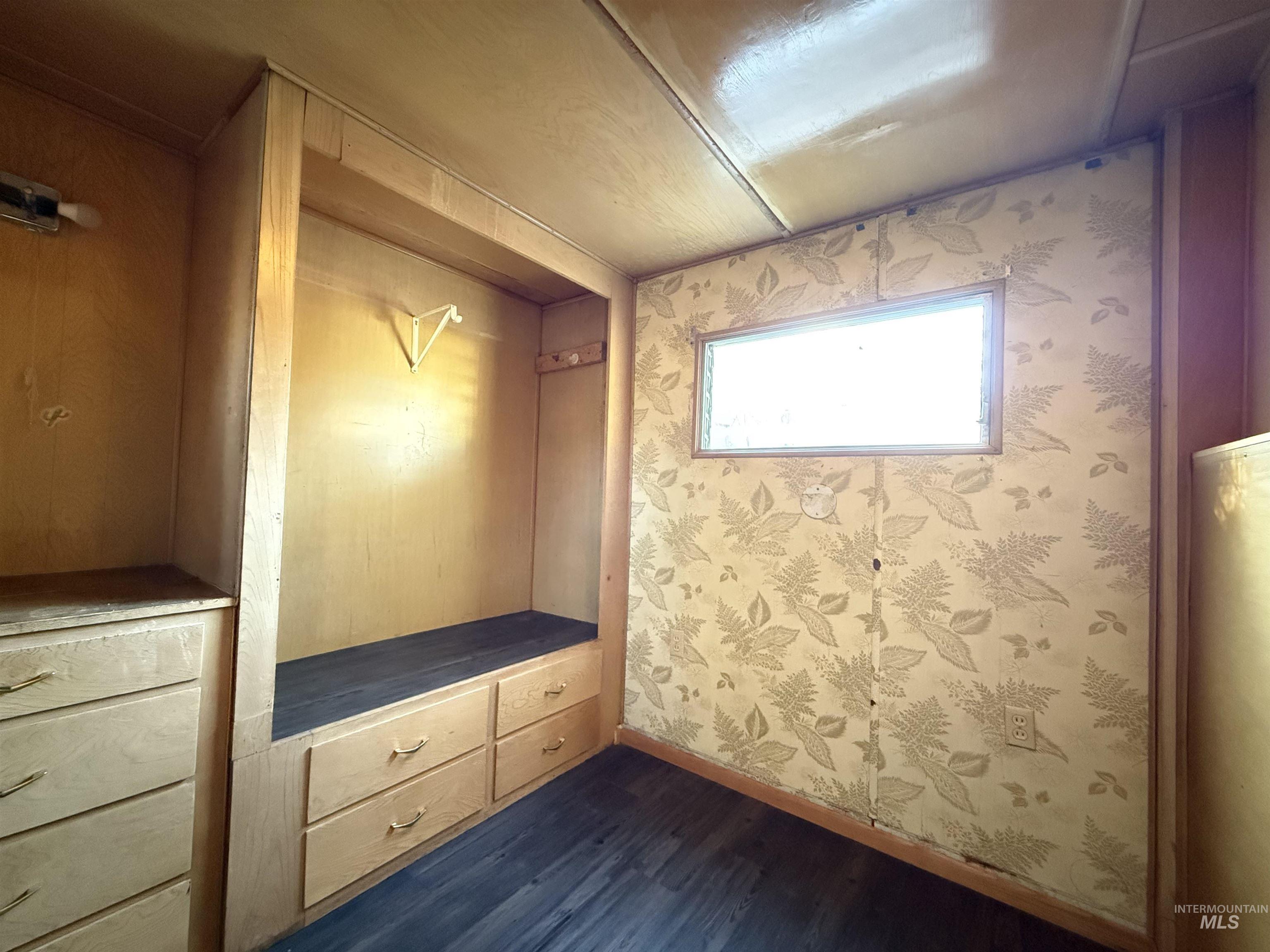 Mudroom featuring dark wood-type flooring and wallpapered walls