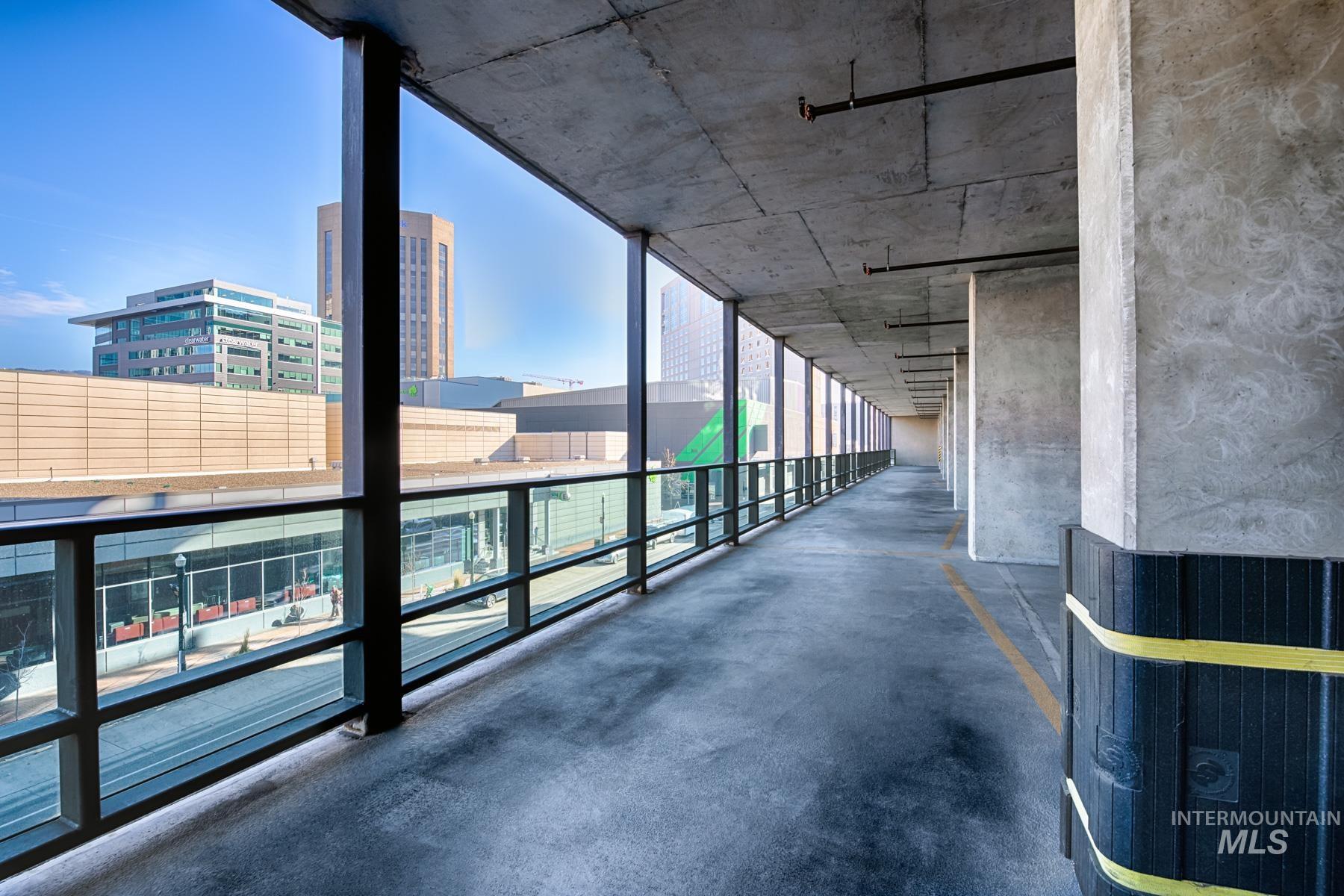 Hallway featuring expansive windows, a city view, and concrete flooring